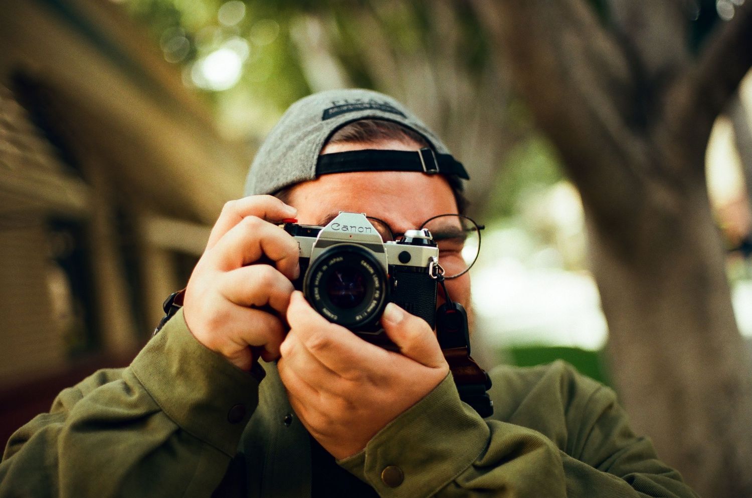 A sequence of hands holding different cameras while taking photographs in natural outdoor lighting.