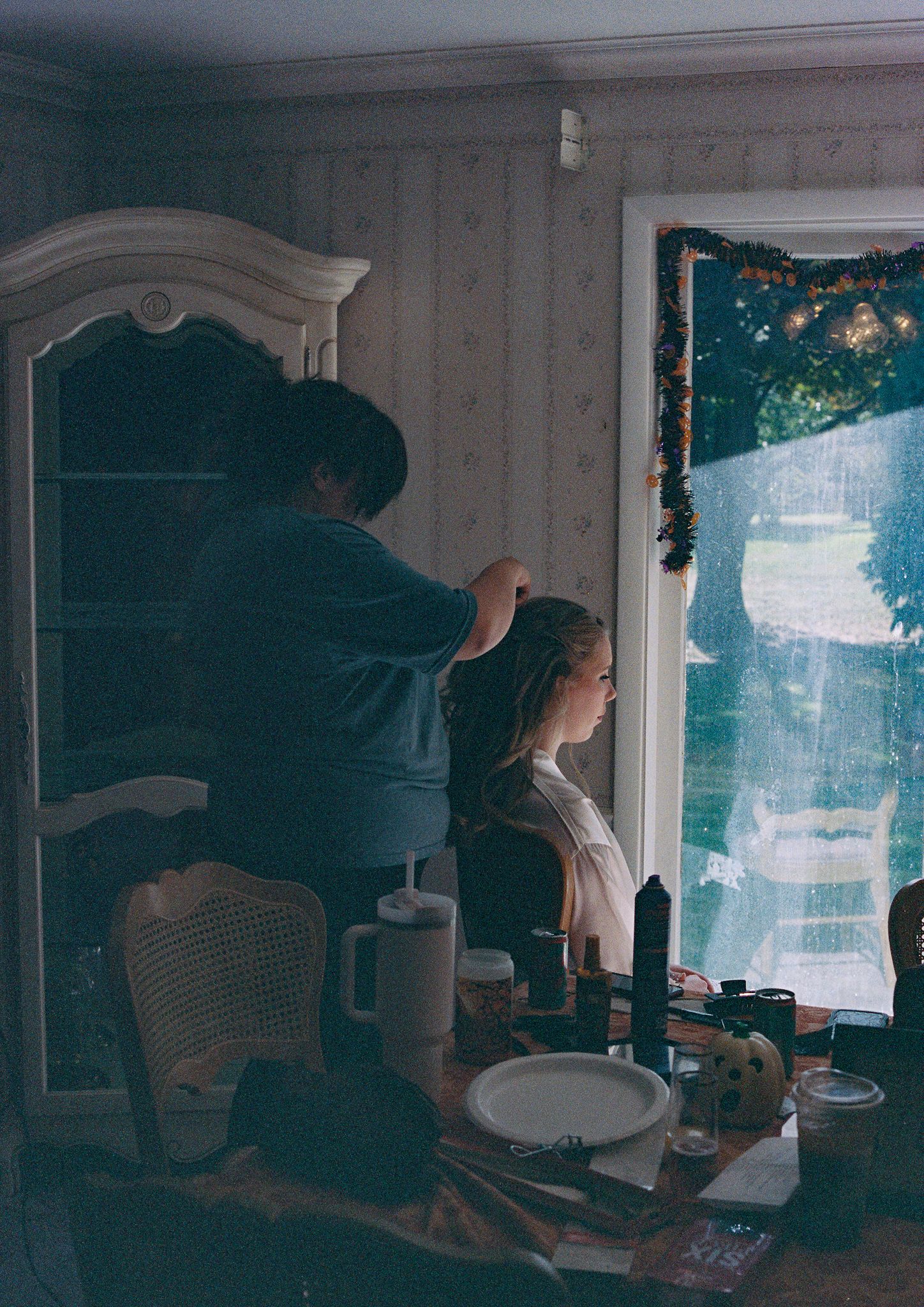 People working together in a dimly lit room with vintage furniture and natural light streaming through windows.