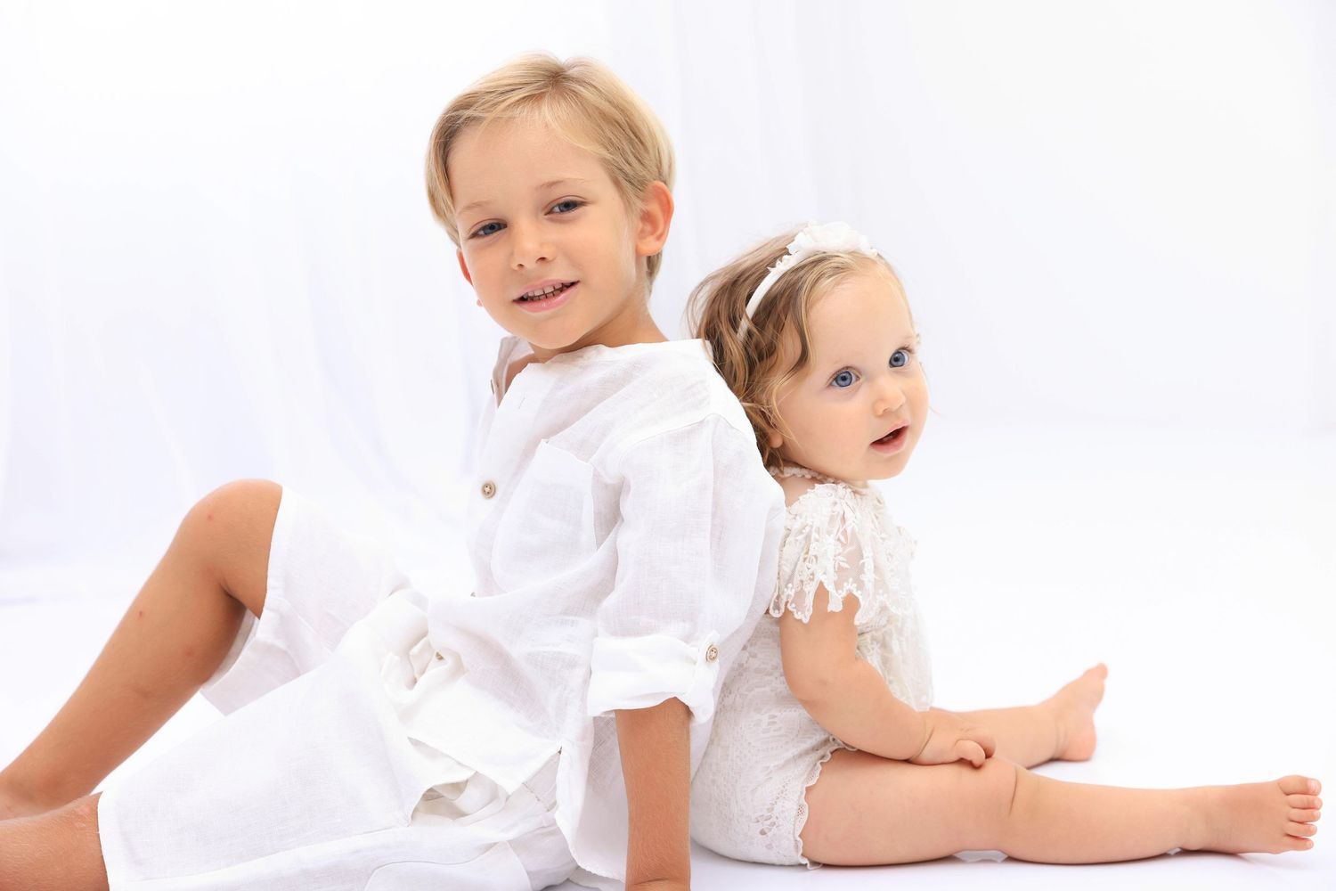 Four tender moments of a family in soft white clothing against a pure white background creating an intimate portrait series.Dubai Photograph