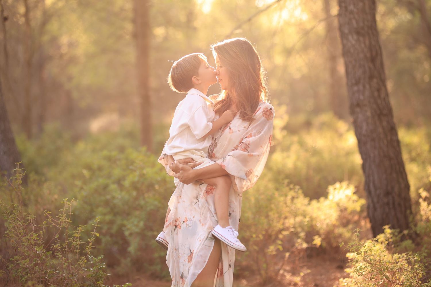 A tender moment captured between parent and child embracing in a sun-drenched forest during golden hour.Dubai Photographer