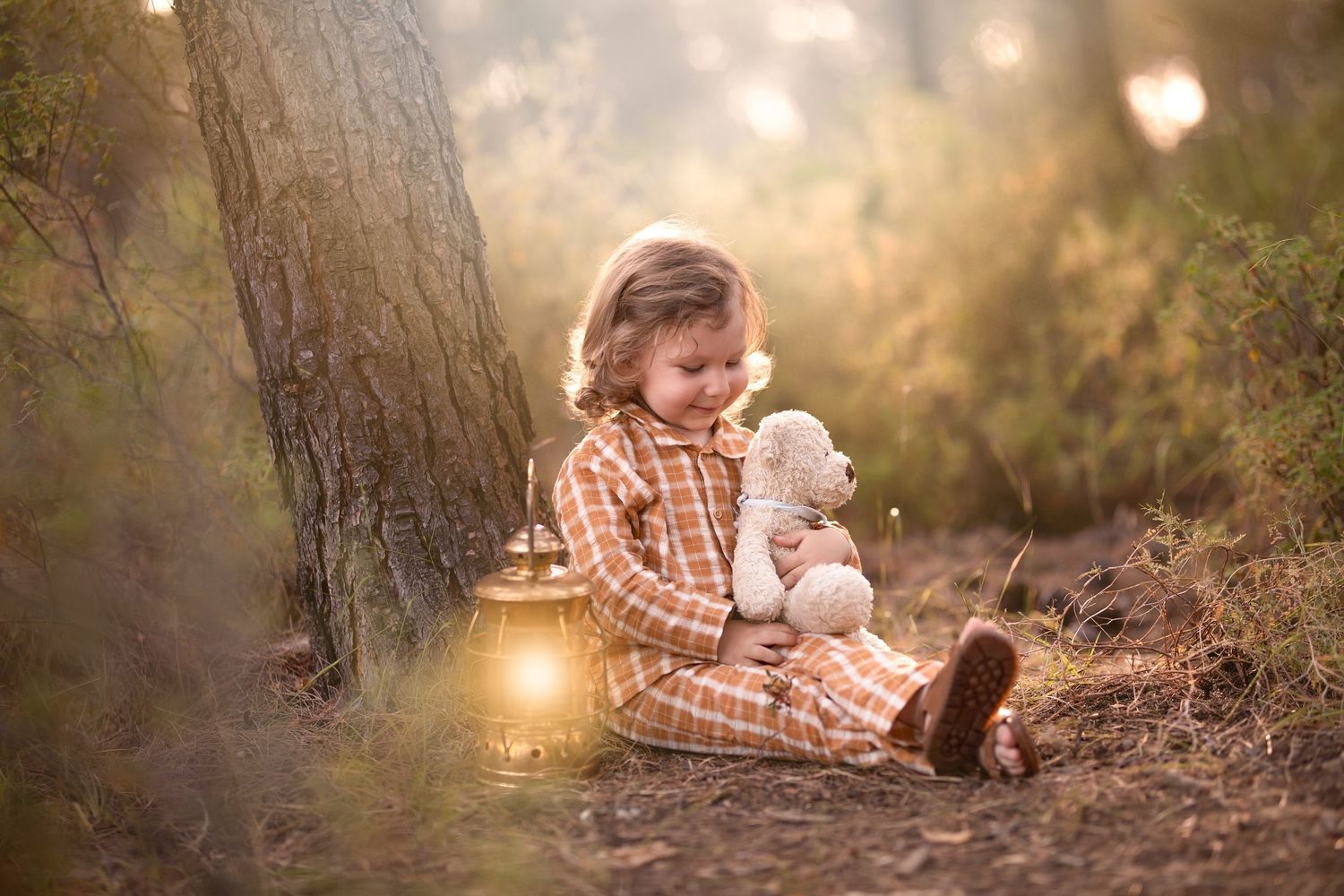 A dreamy forest scene with a glowing lantern and stuffed bunny companion in soft evening light. Dubai Photographer