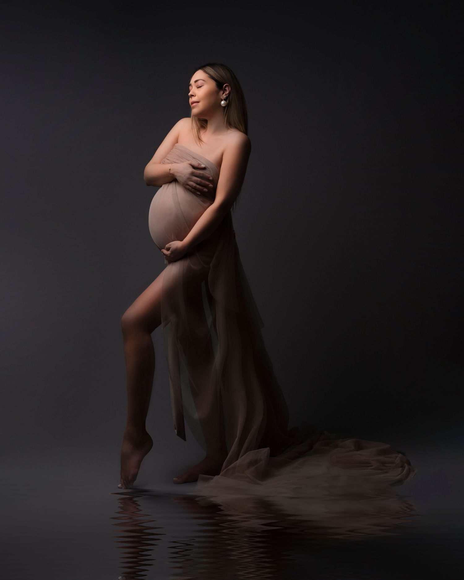 Artistic maternity silhouette in dark dramatic lighting. Dubai Photographer