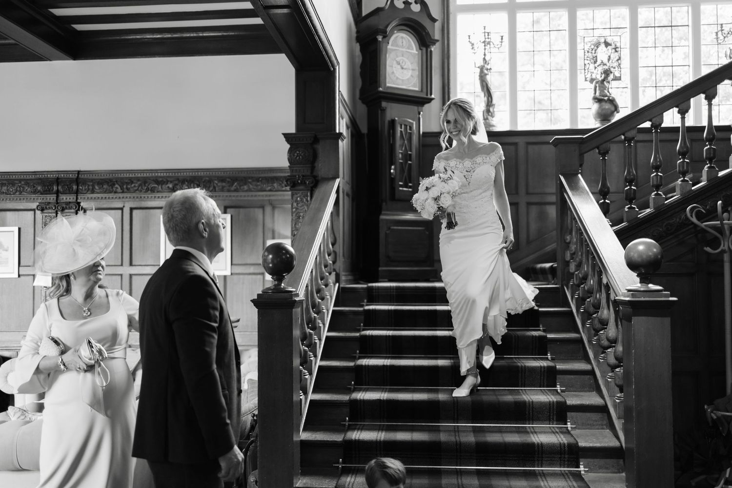 Black and white wedding photos captured on an elegant staircase with natural window light.