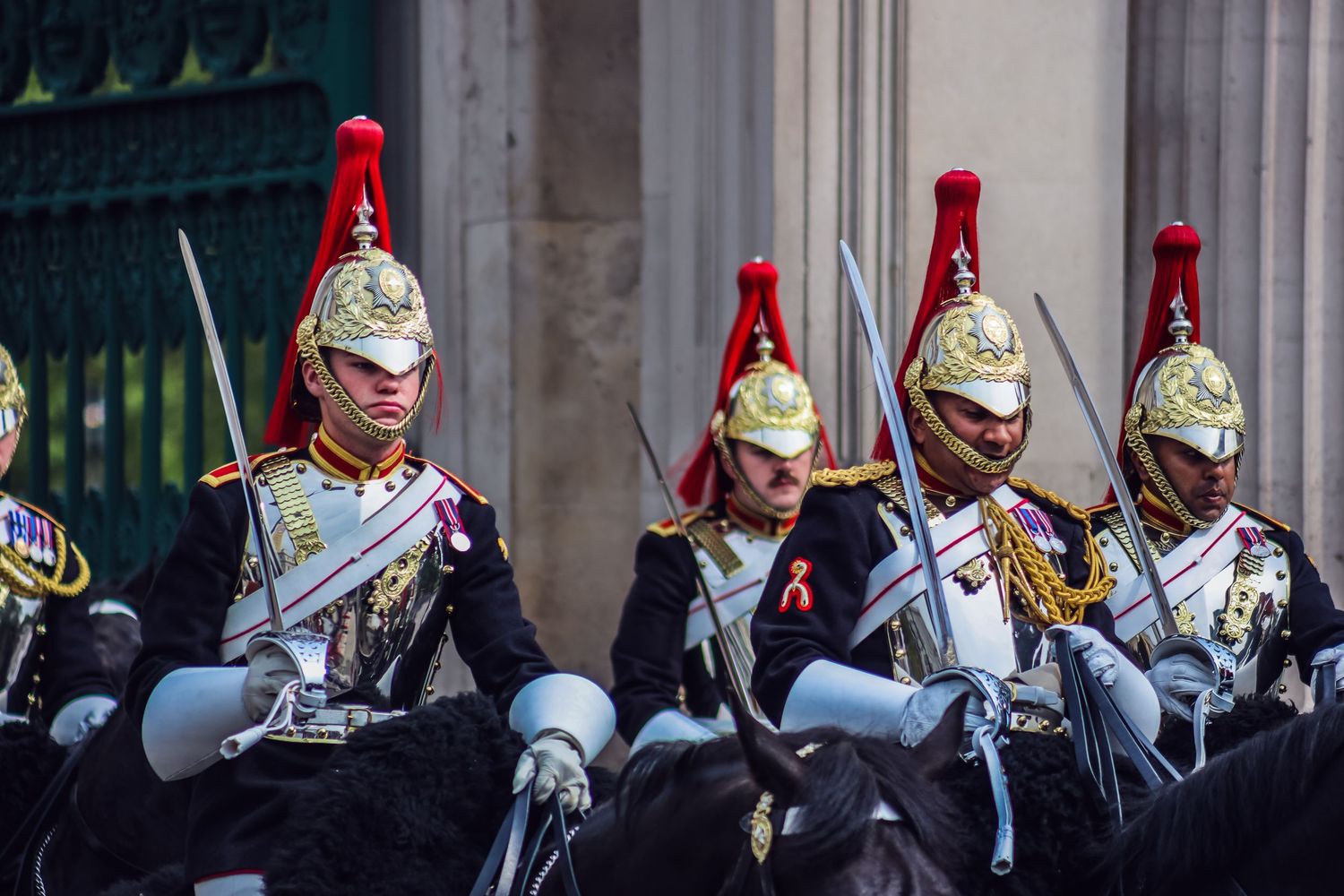 Royal guards in ceremonial uniforms with bright red plumes and gold helmets.
