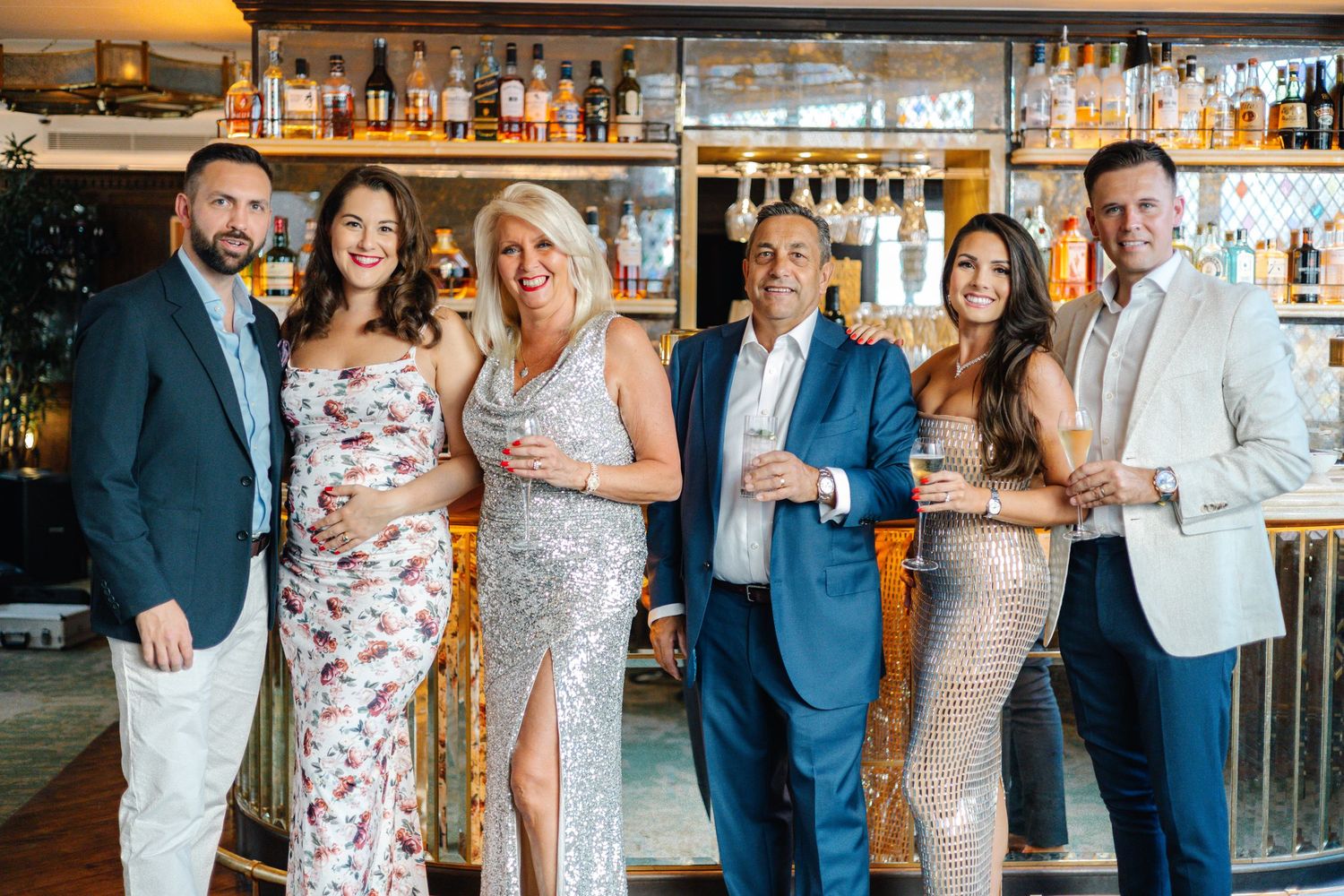 Guests gathered at a bar for celebration with drinks and smiles.