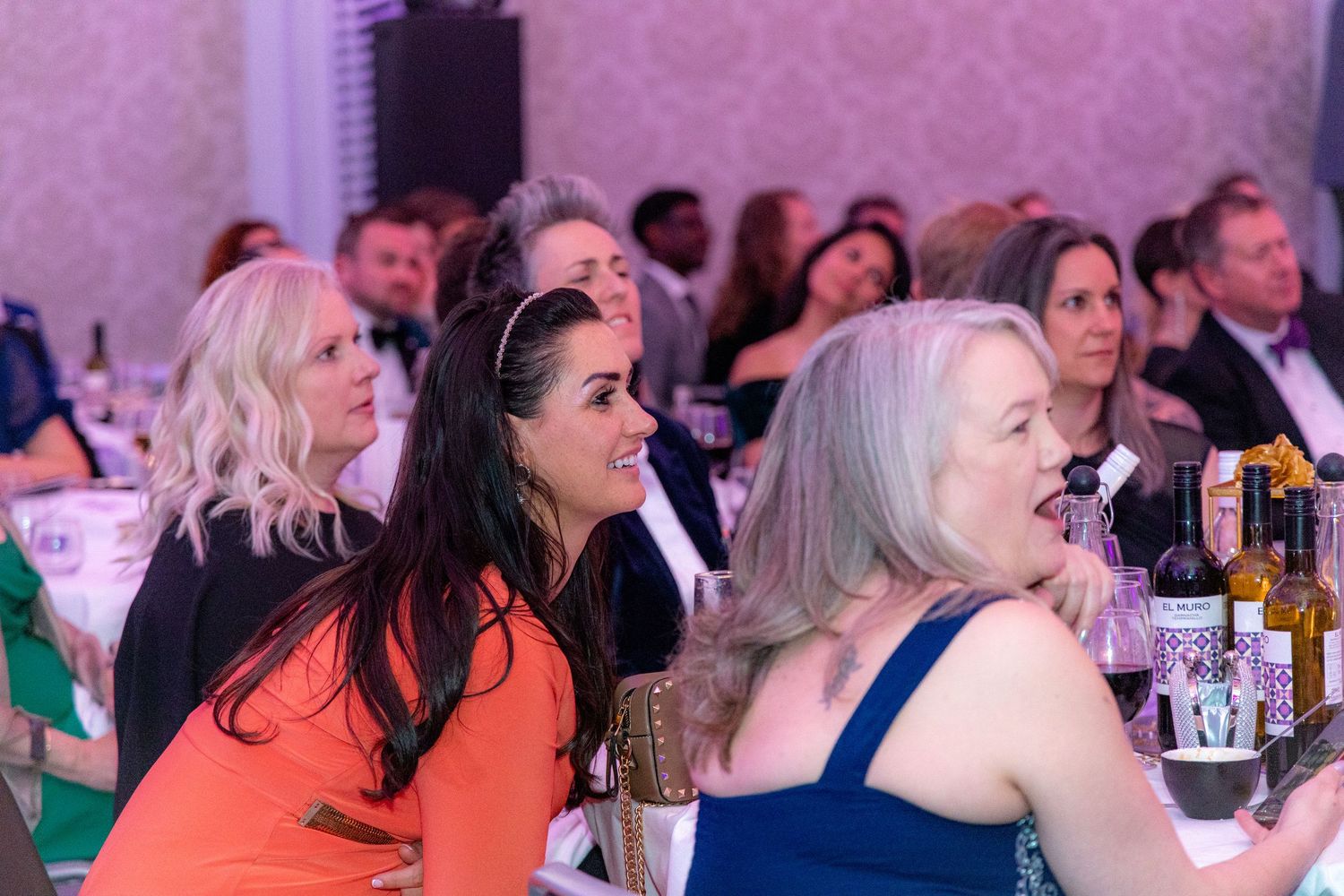 Guests seated at round tables during an evening gala event.