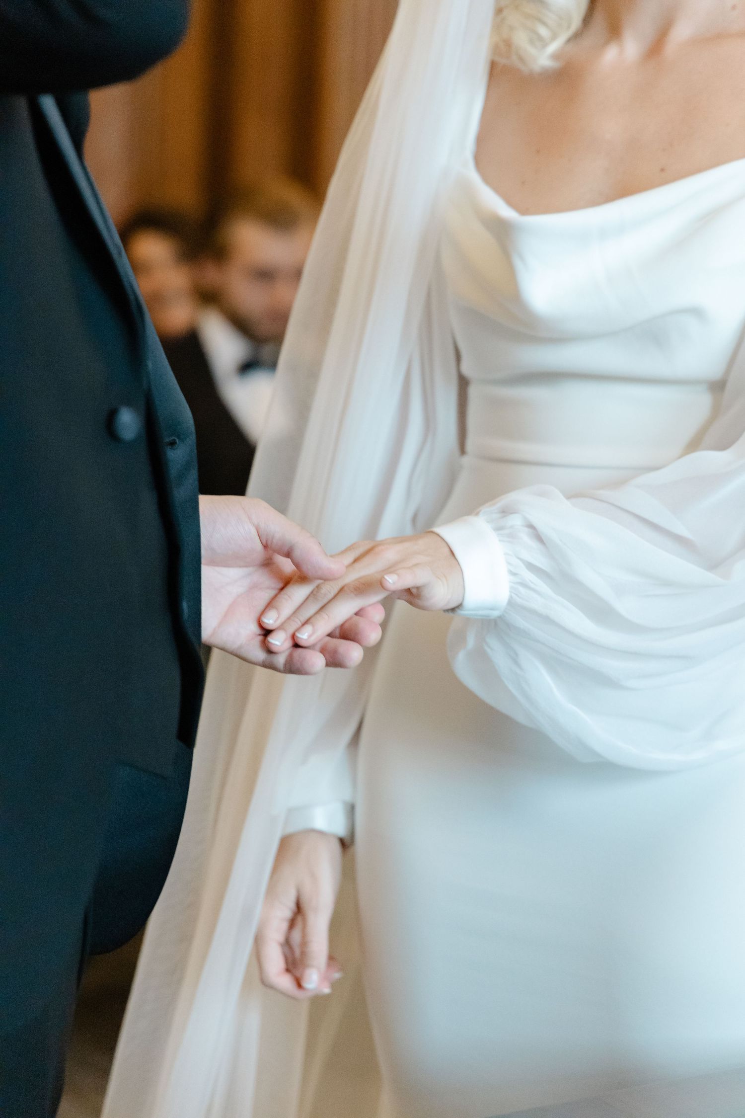 Detail shots of a bride's dress being buttoned up during wedding preparations.