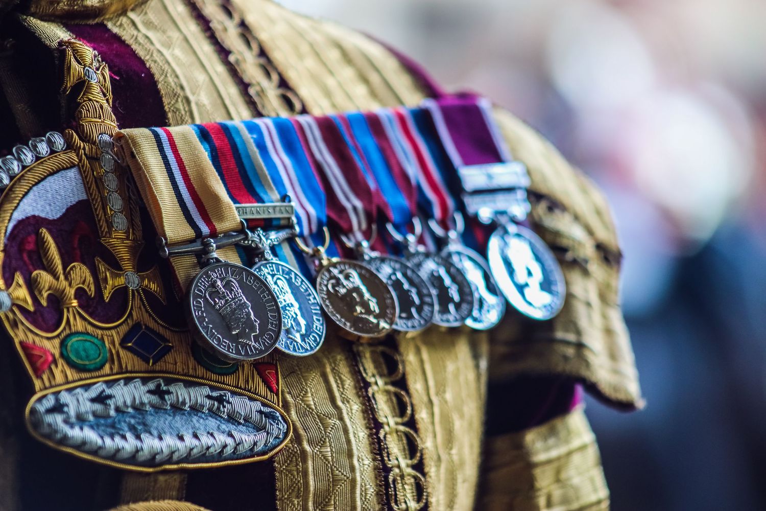 Military medals and decorations displayed on ceremonial uniform fabric.