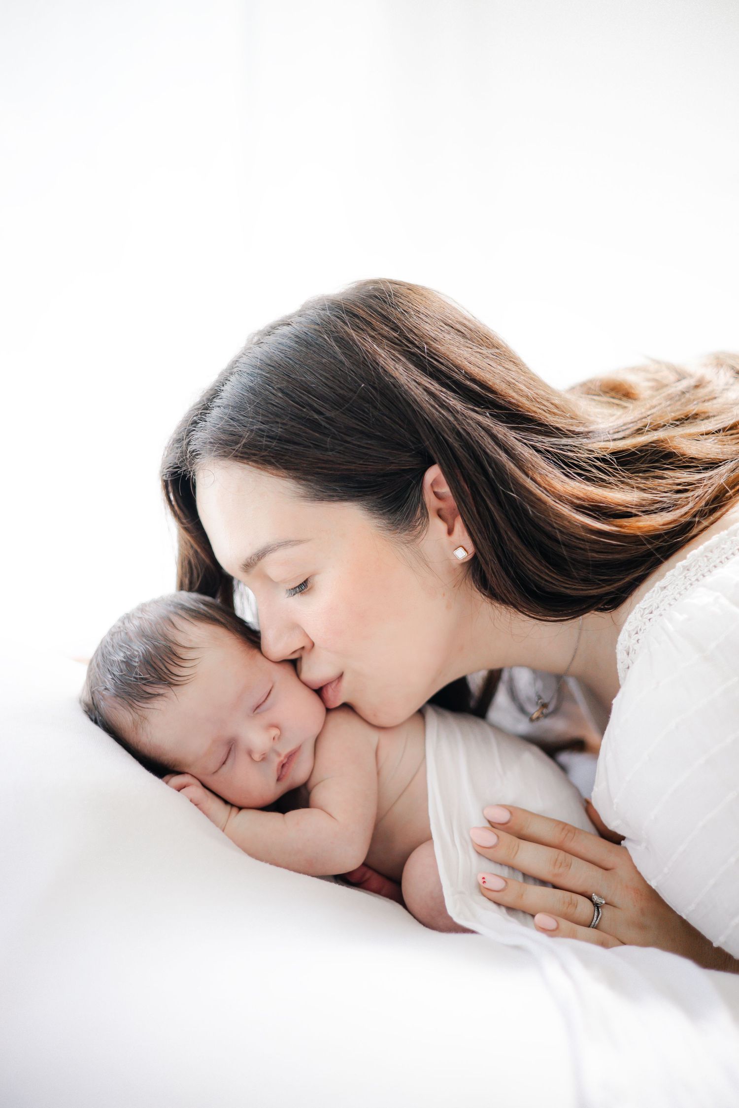Intimate mother and child portrait series against white background.