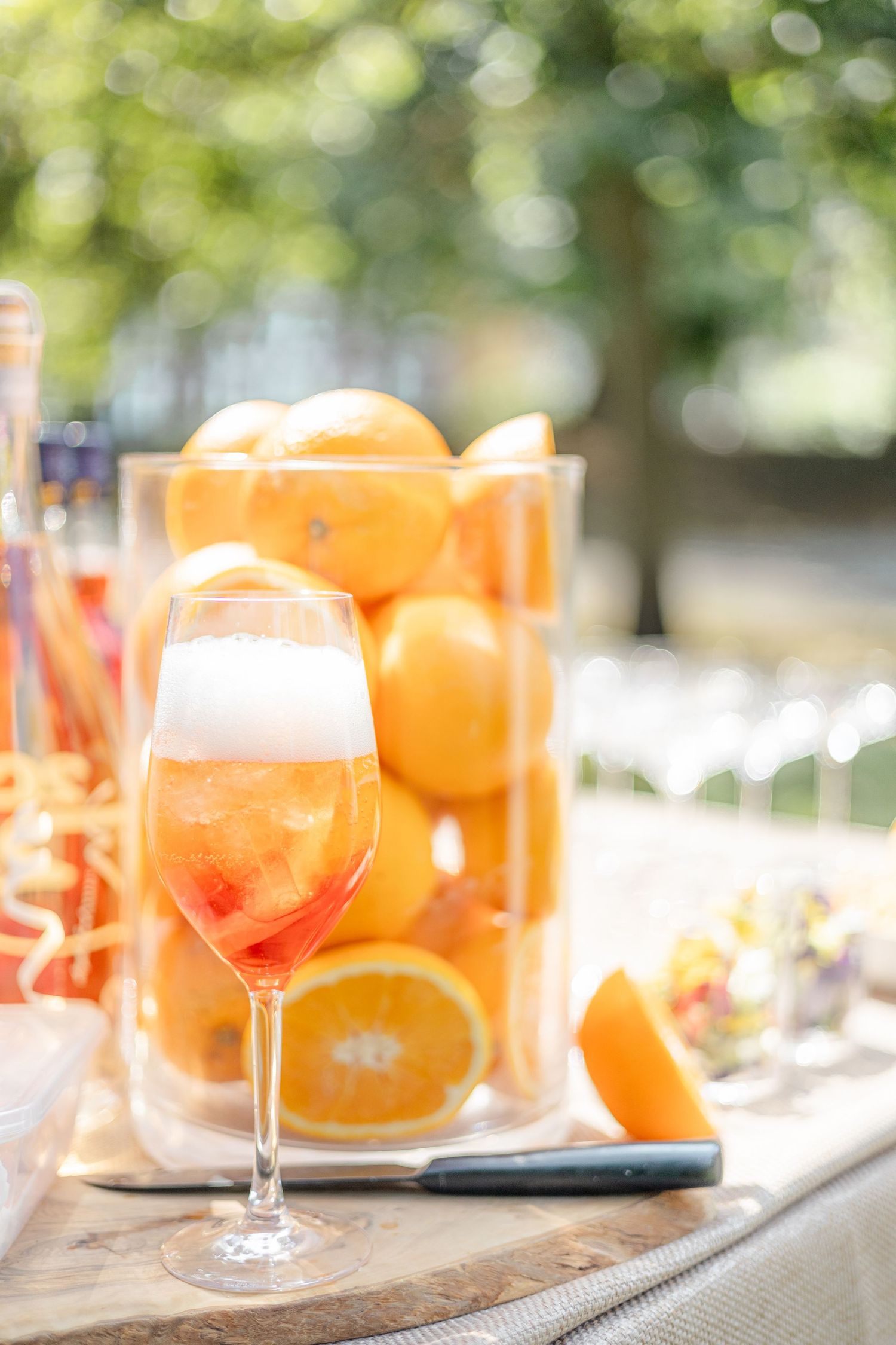 Orange cocktails and citrus fruits arranged on a rustic wooden serving board.