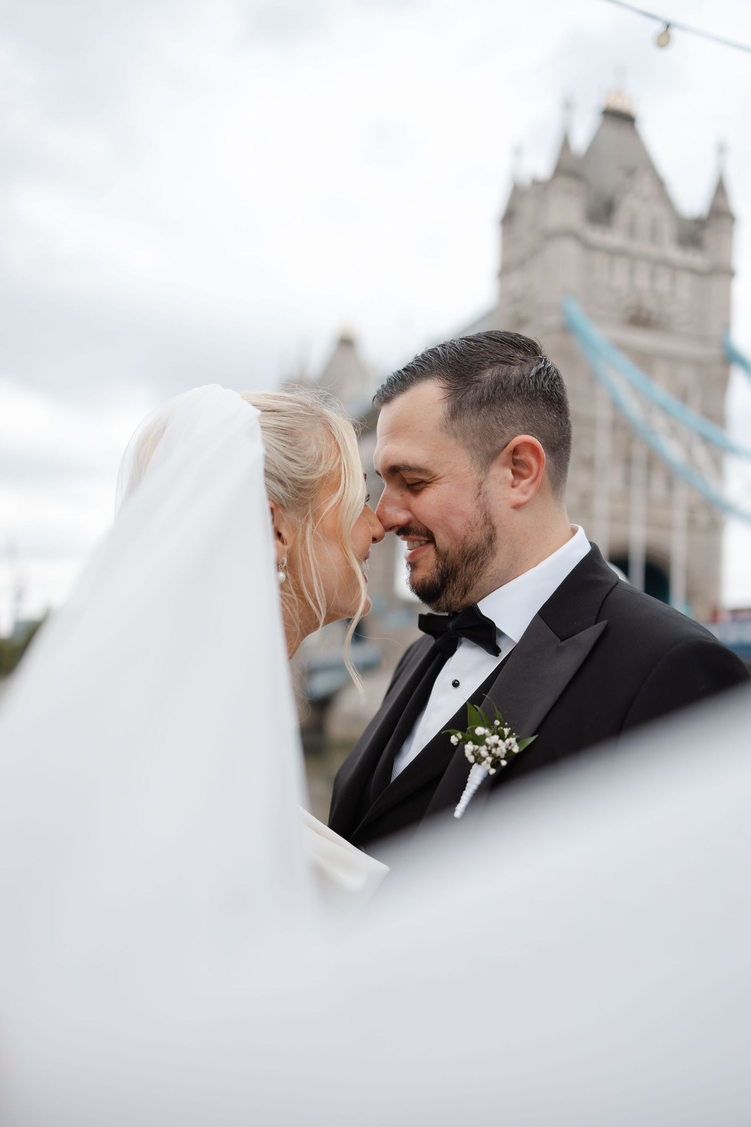 Intimate wedding portraits captured with London's Tower Bridge in soft focus.