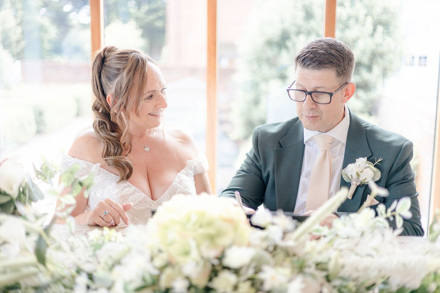 Elegant wedding reception table setting with floral arrangements and natural lighting.