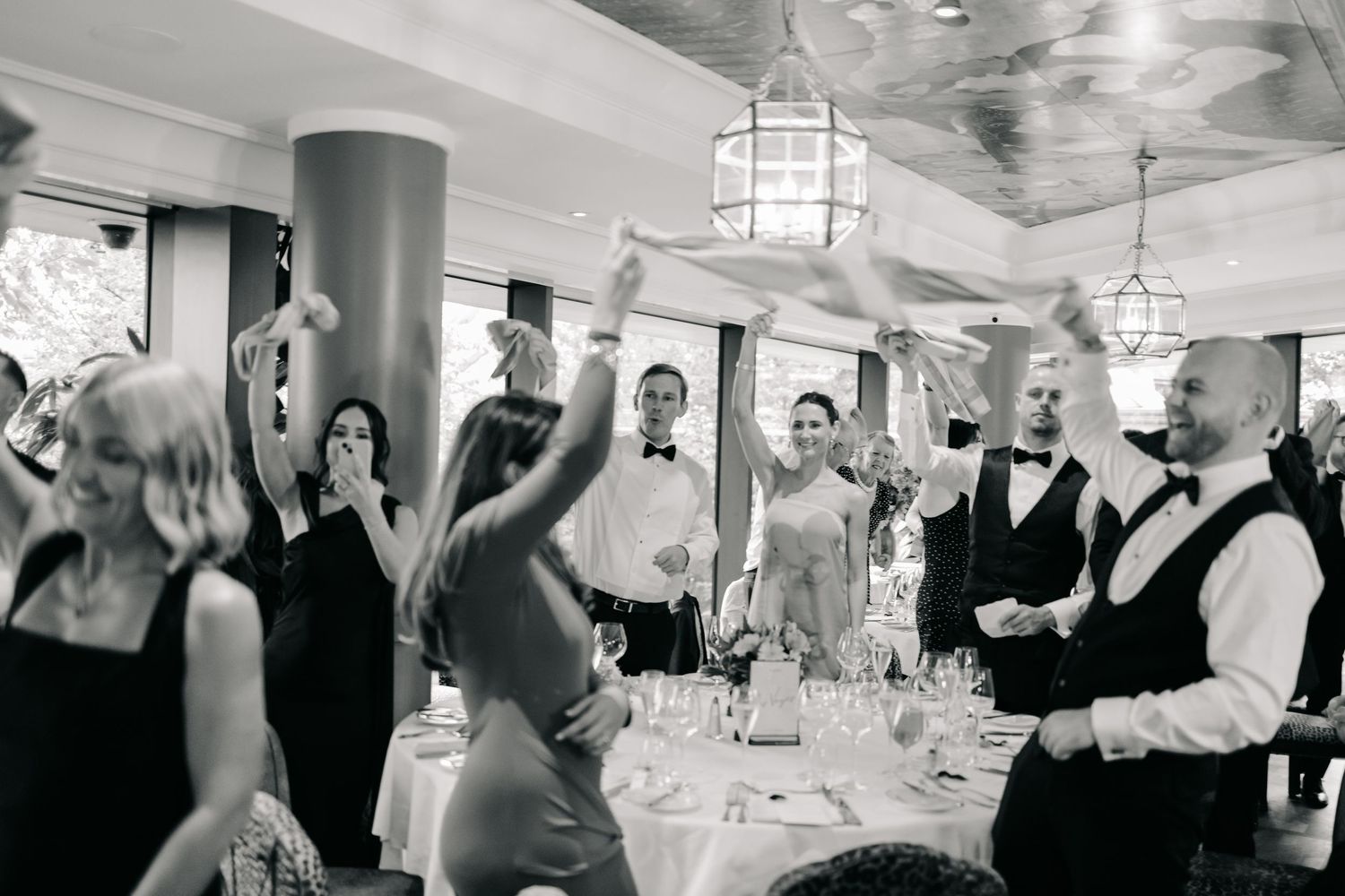 Wedding reception celebration with guests dancing in elegant indoor venue.