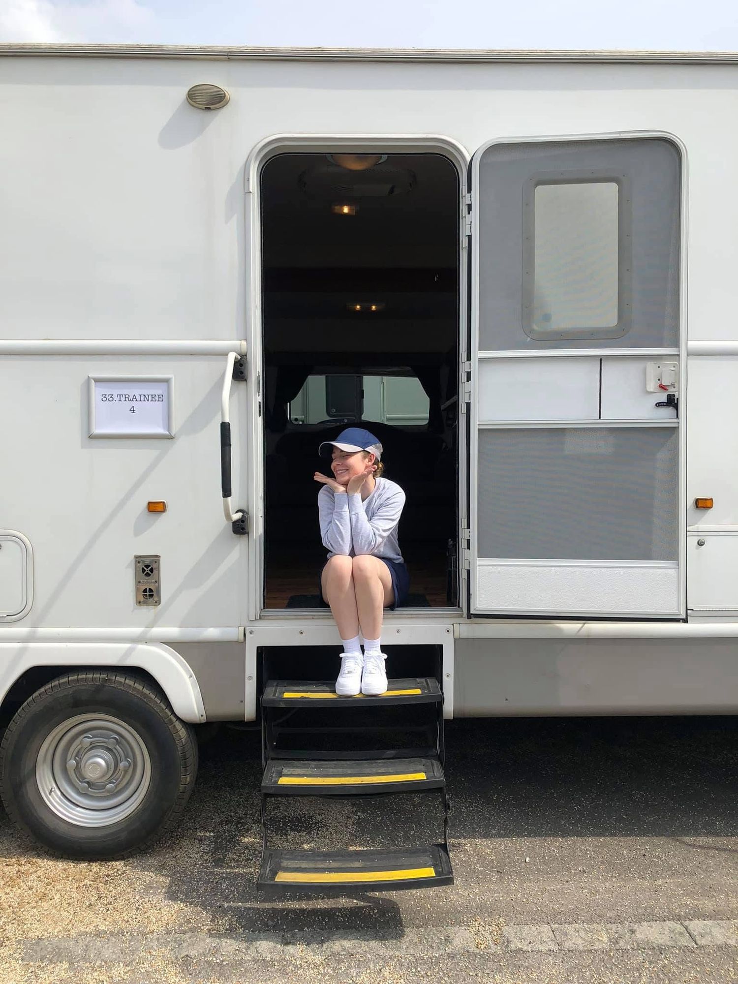 A sequence of photos showing someone sitting in the doorway of a white RV or camper van parked outdoors.