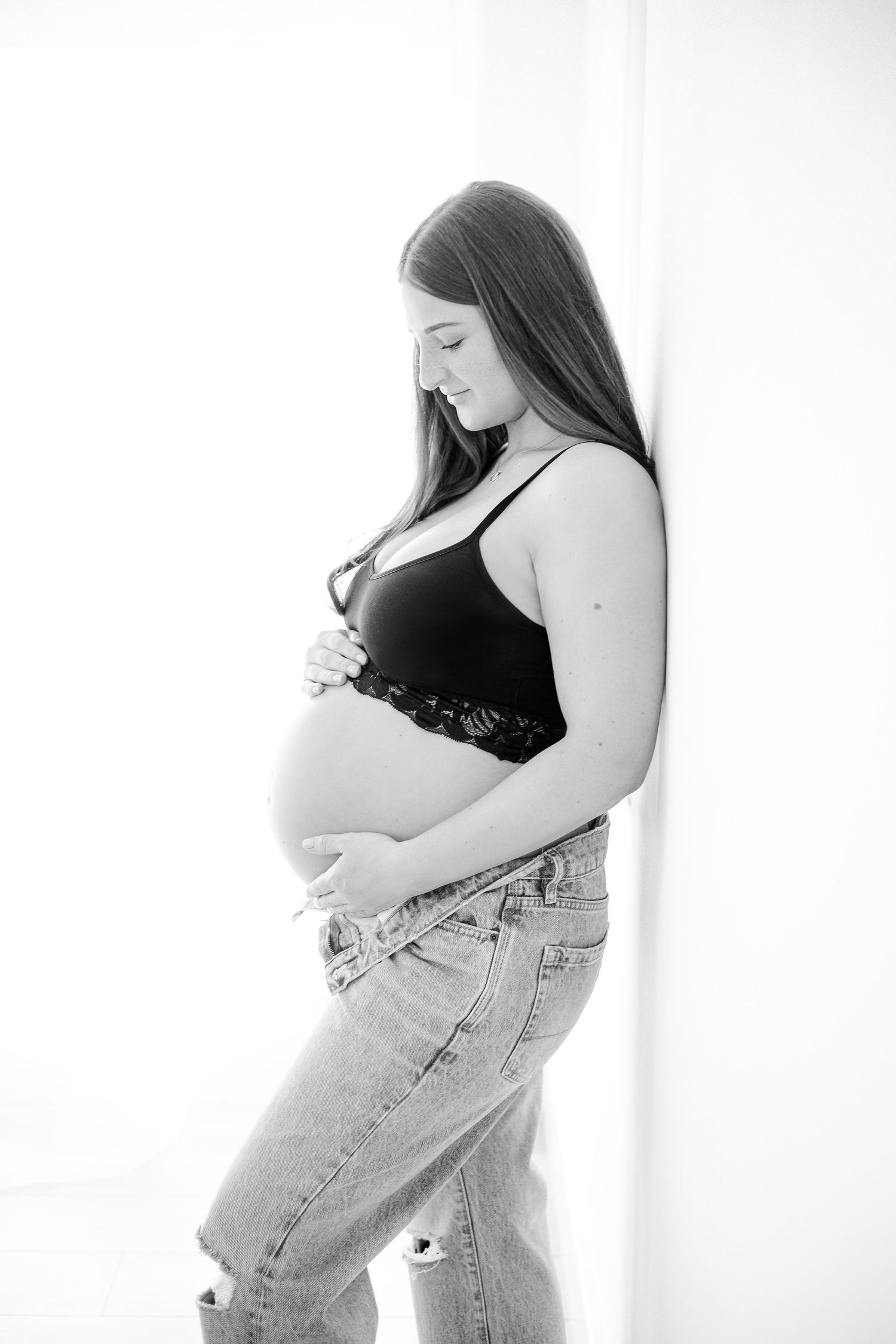 Black and white maternity portraits showing pregnancy in casual denim style.