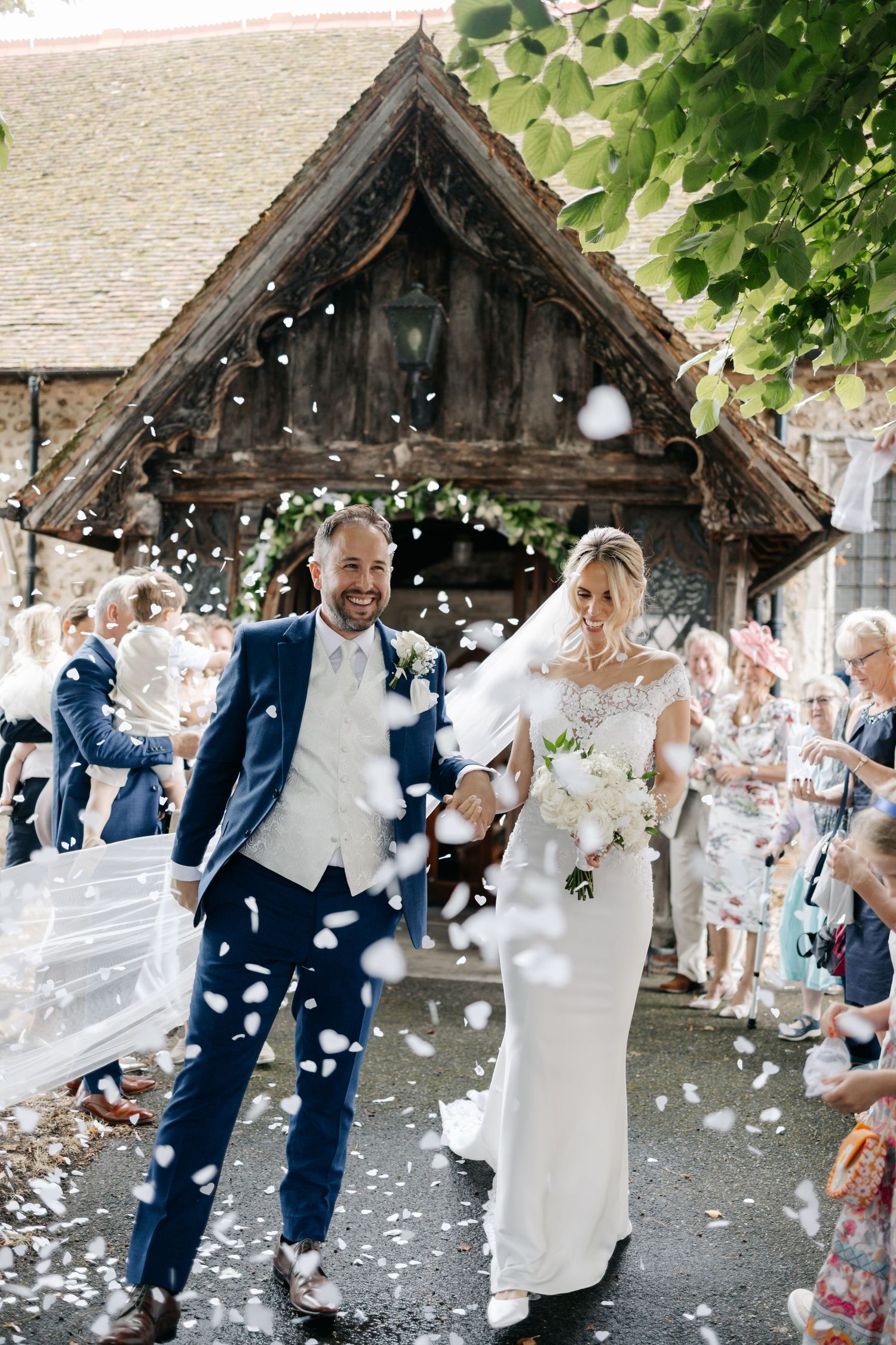 Wedding guests shower newlyweds with white confetti.
~ Essex Wedding Photographer