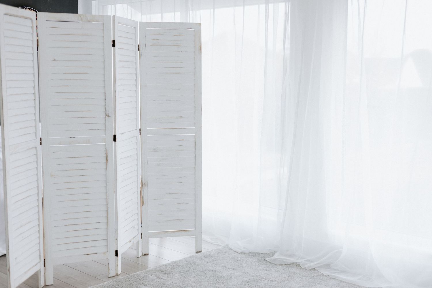 Bright white studio interior with louvered doors and natural lighting.