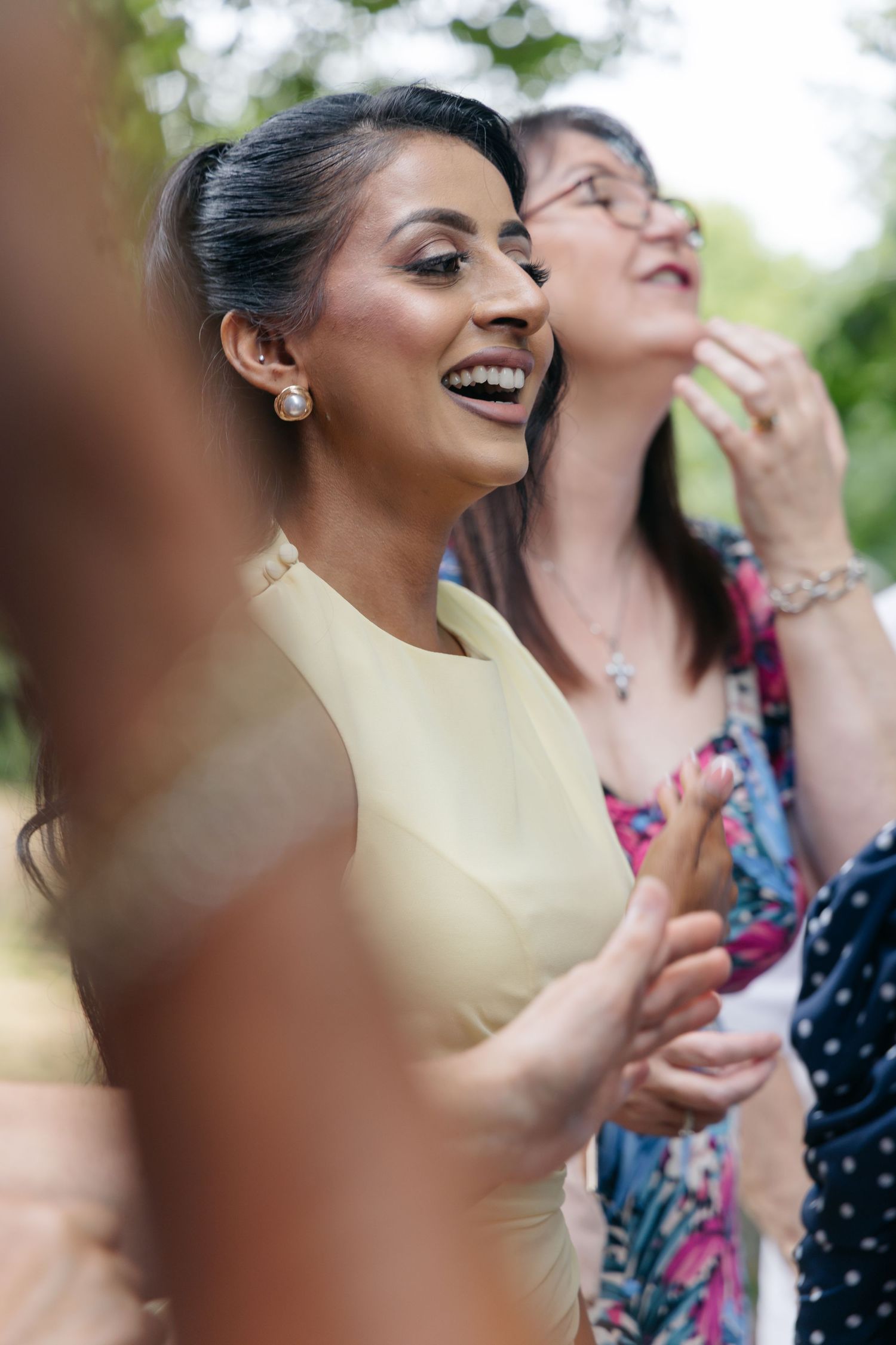 Wedding guests laughing and enjoying outdoor celebration.
