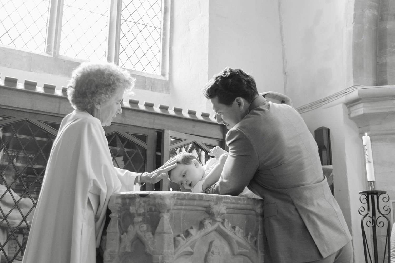 Two people gather around a baptismal font in a church setting.
