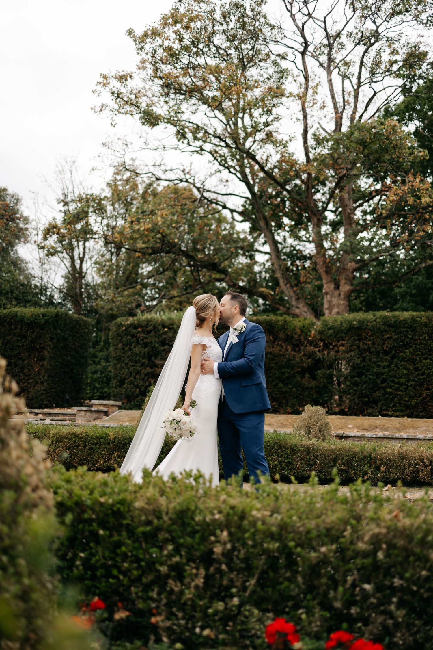 A romantic wedding couple shares a tender kiss in a garden at Greenwoods wedding venue.
~ Essex Wedding Photographer