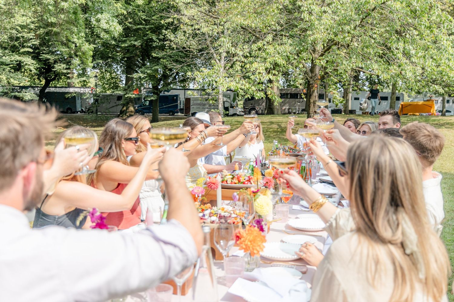 Festive outdoor party scene with decorative table settings in a garden.