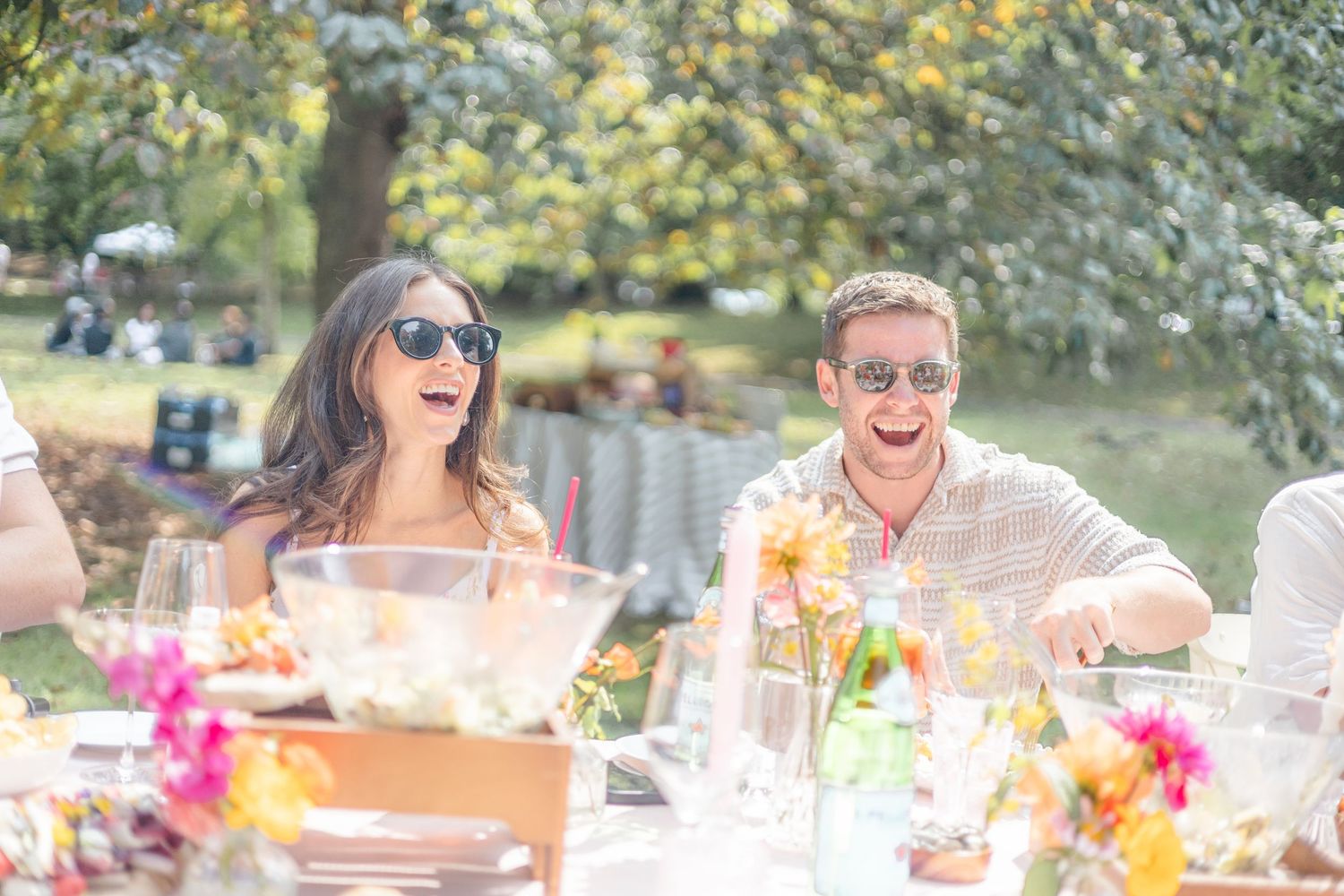 Summer outdoor dining setup with floral arrangements and place settings.