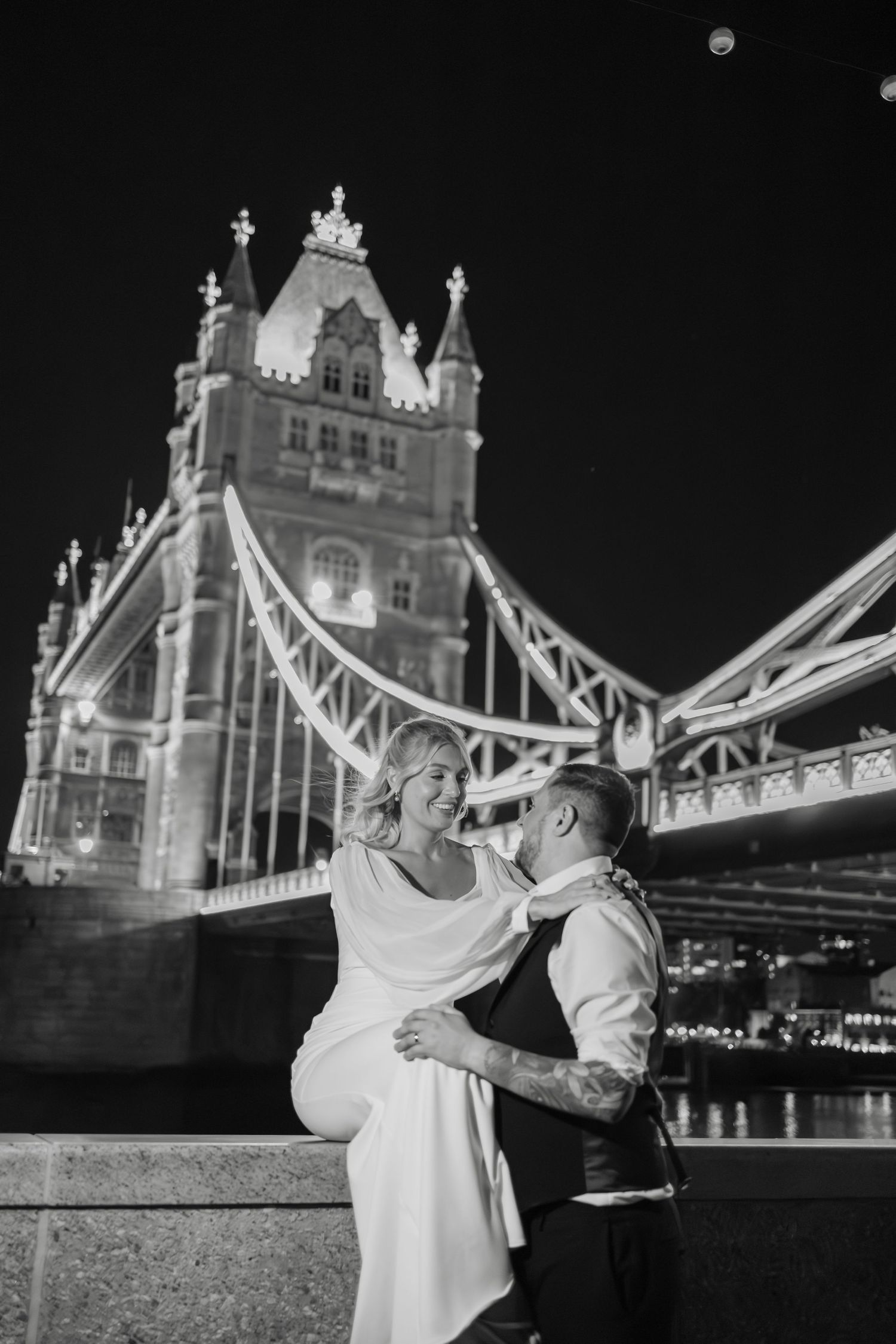 Romantic nighttime photos in front of the illuminated Tower Bridge in London.