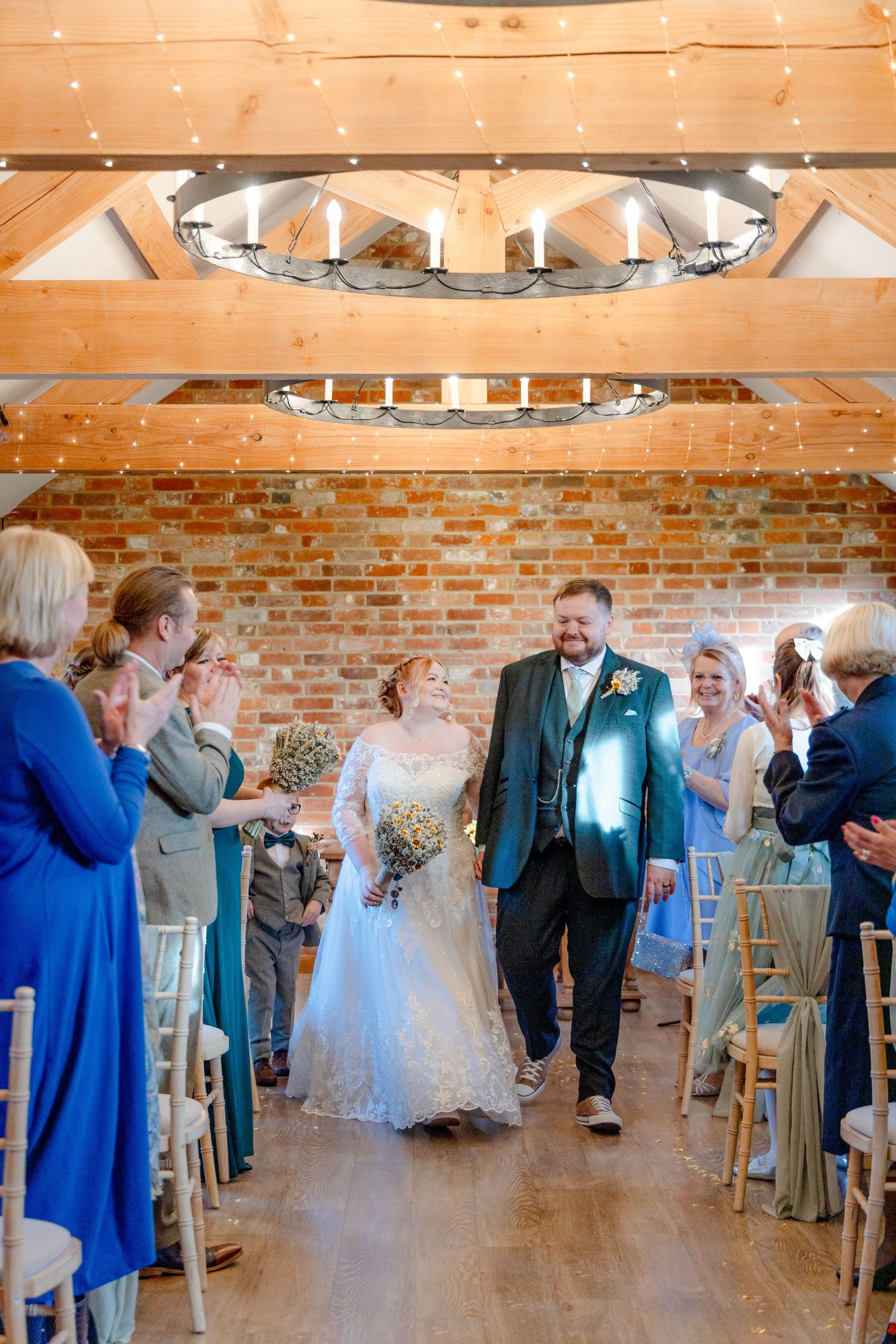 Wedding reception in a rustic barn venue with exposed brick walls and string lights.
