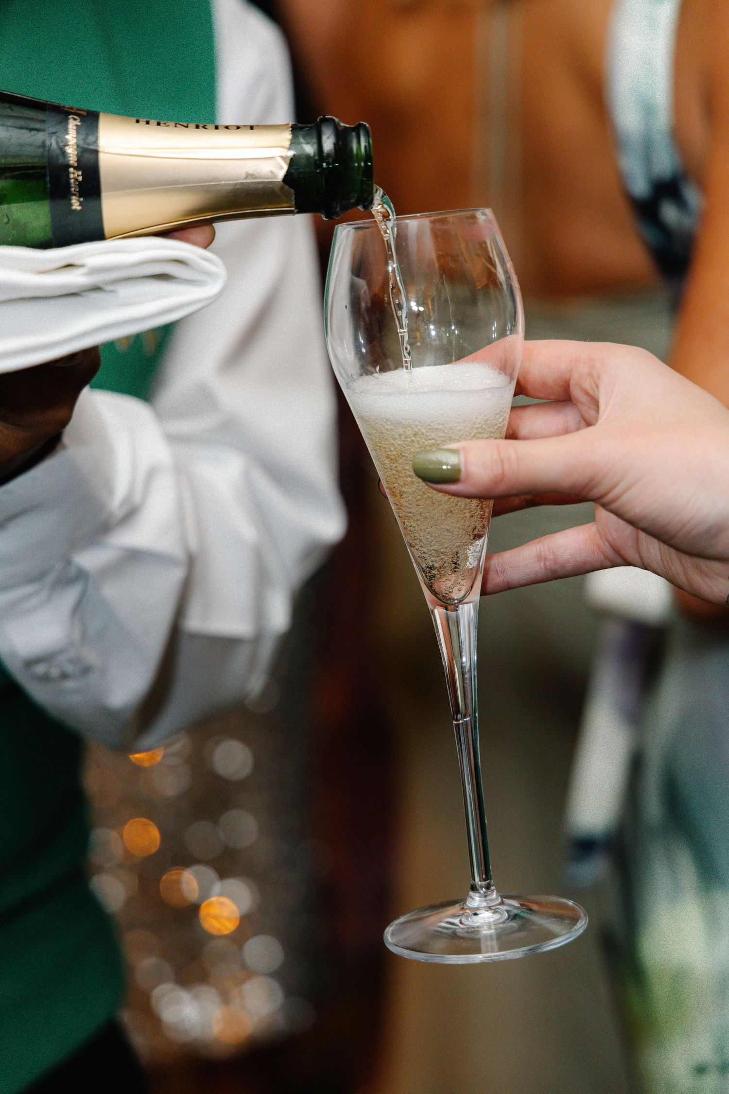 Champagne glasses clink together in a celebratory toast at an elegant event.