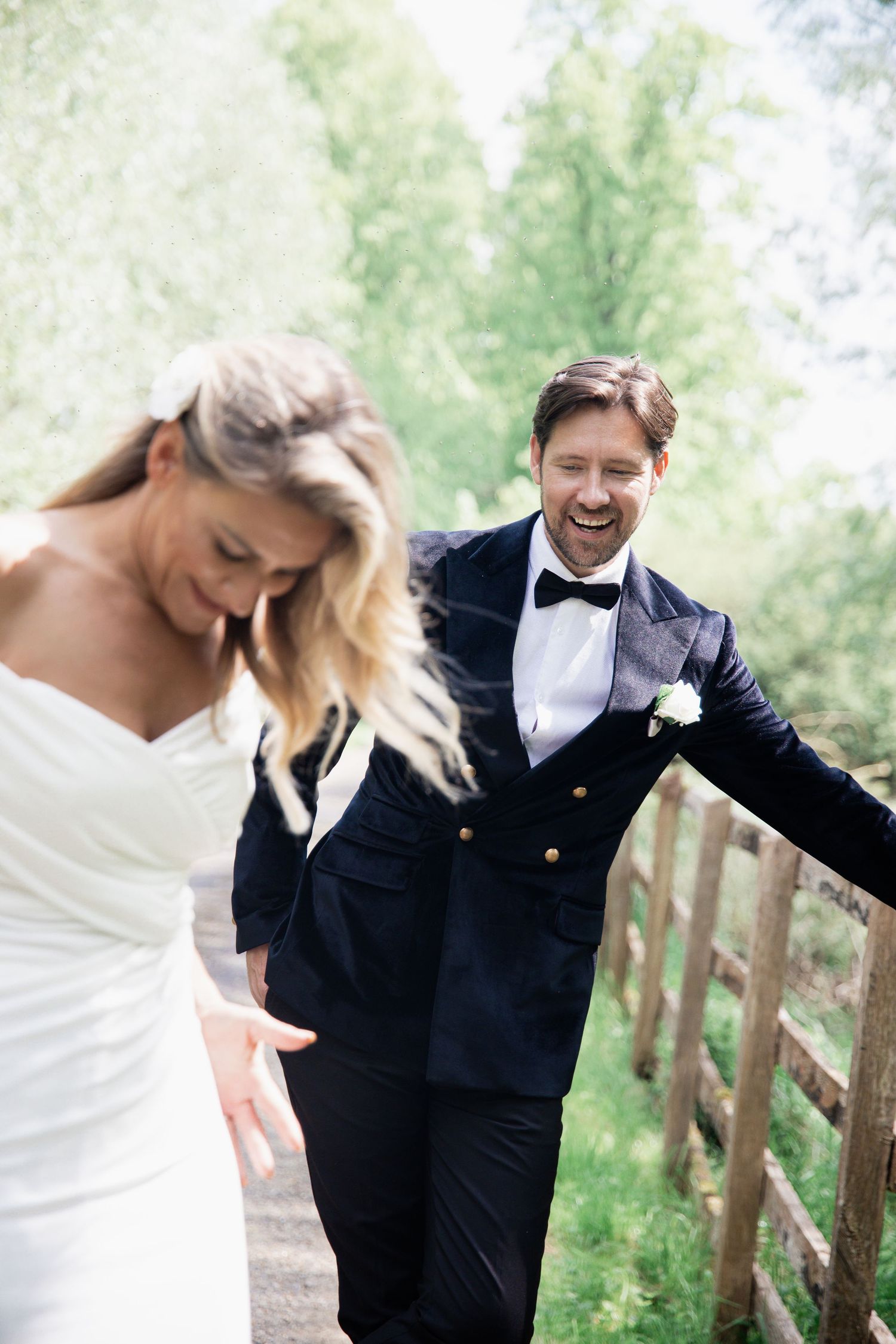 Candid wedding moments captured as couple shares laughter in an outdoor setting.