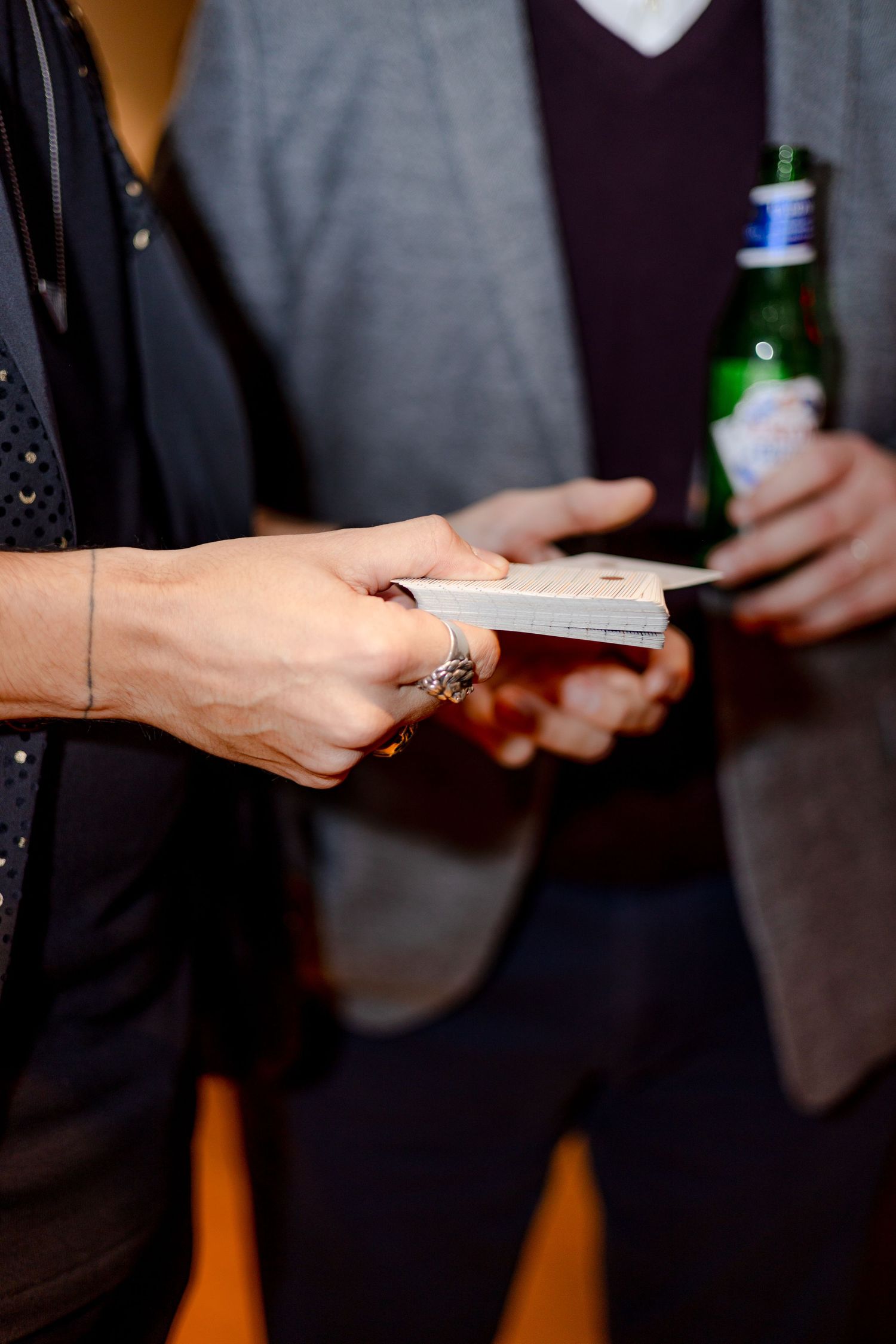 Close-up of hands exchanging business cards at a networking event.