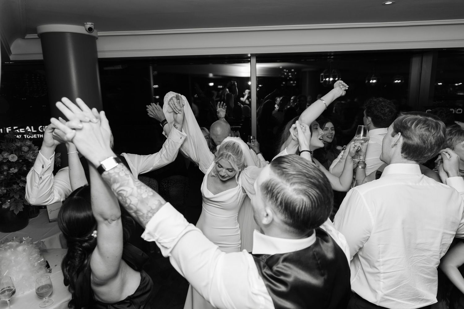 Wedding reception dance floor filled with guests dancing and celebrating.