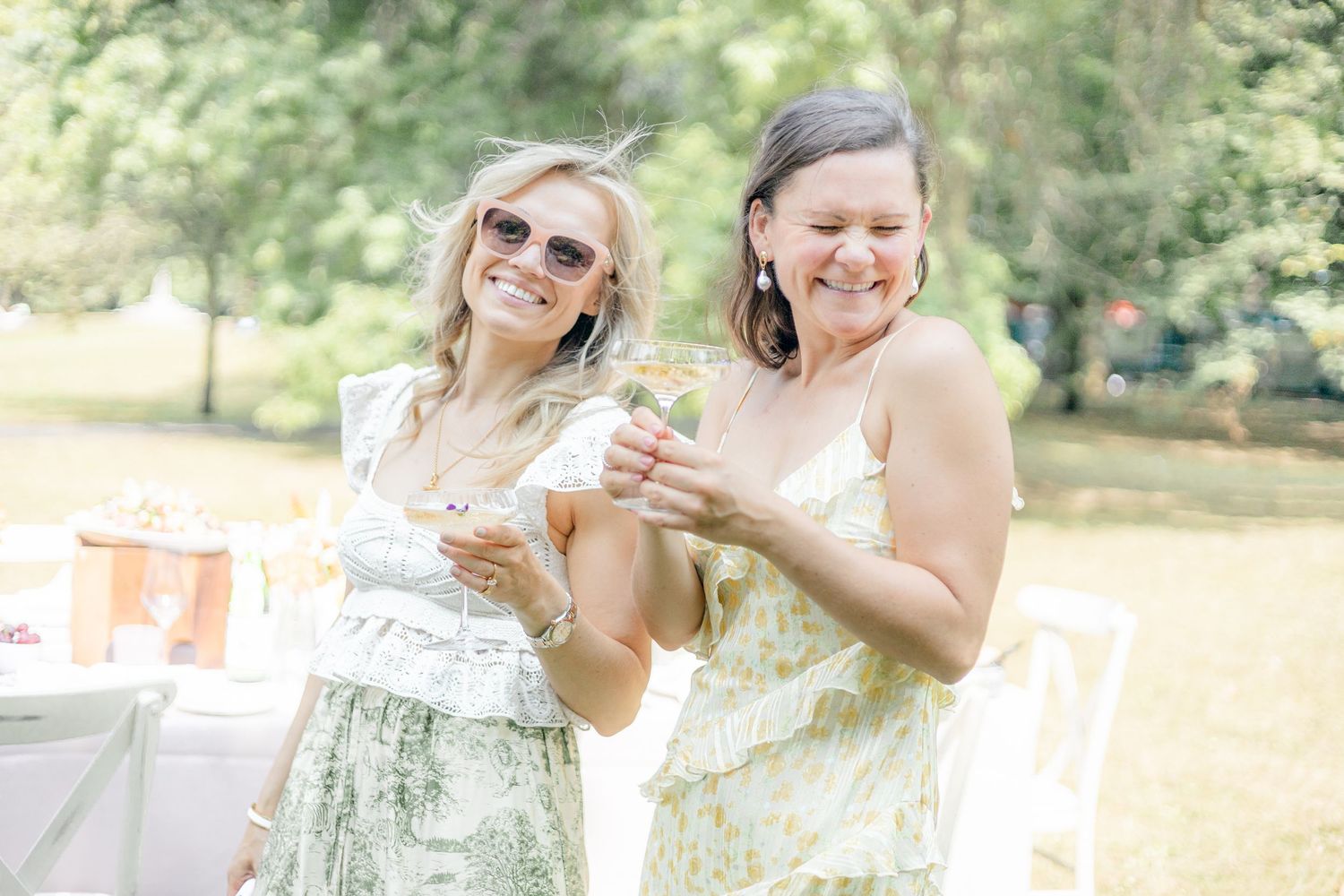 Friends enjoying drinks and laughter at an outdoor summer garden party.