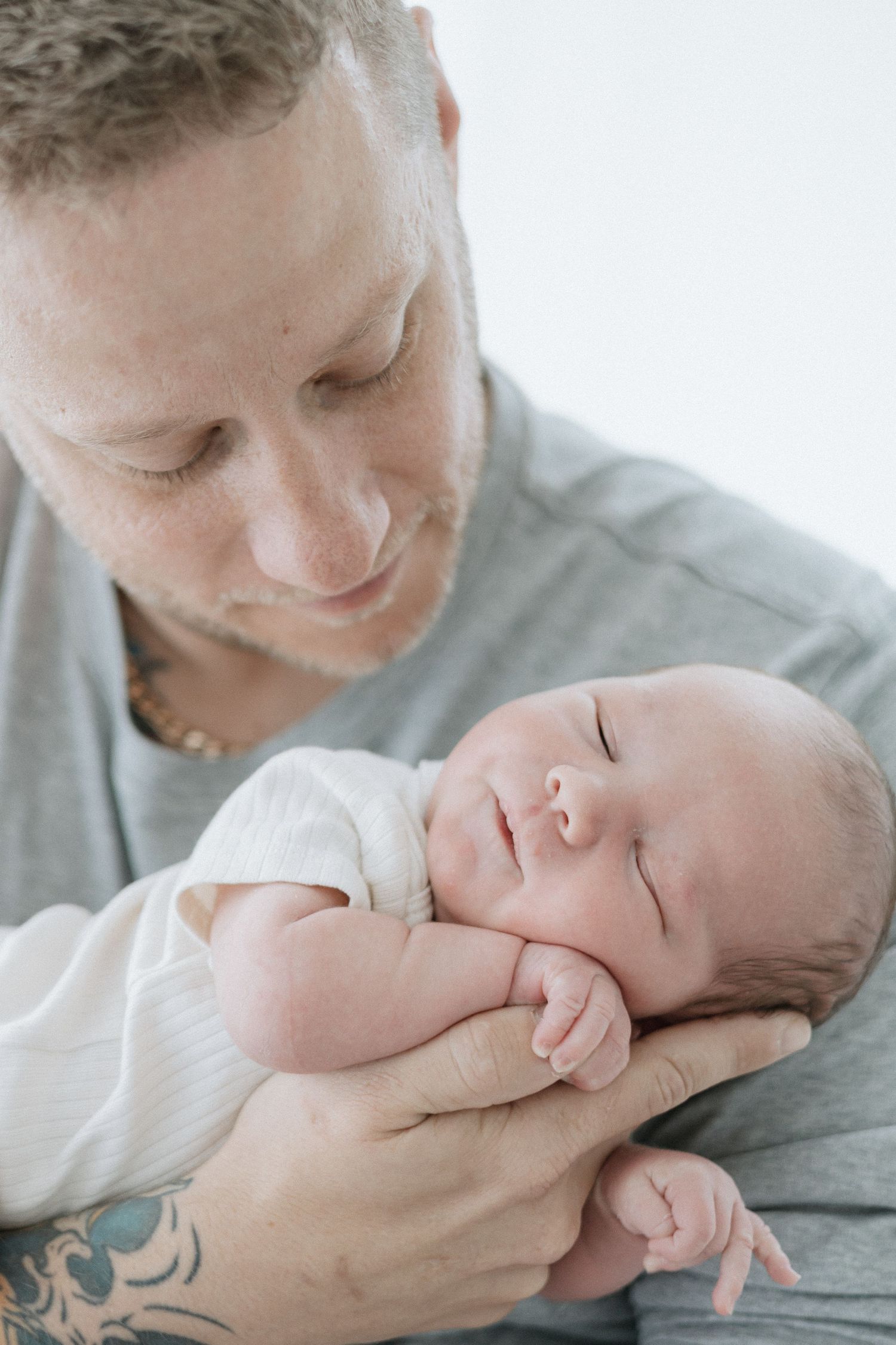 Tender moments captured between parent and newborn in soft natural light.