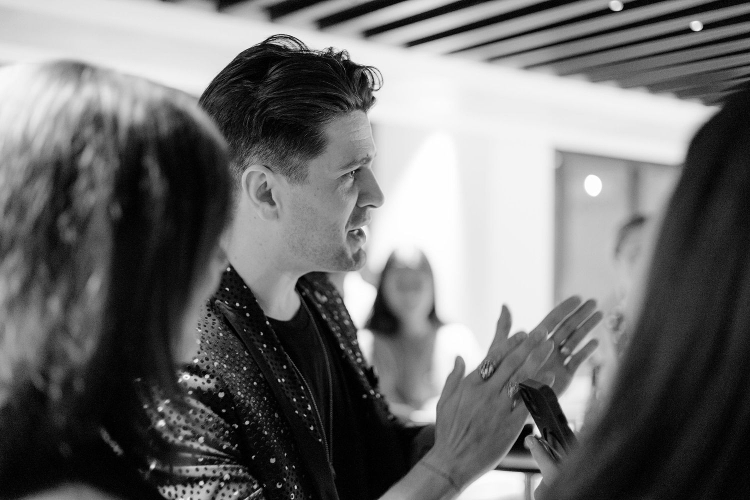 Black and white photo of people interacting at a social gathering.