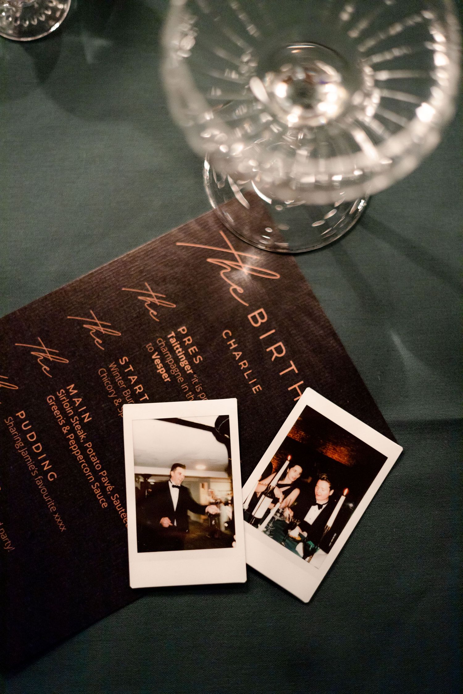 Vintage polaroid photos displayed alongside dark menu cards on a table.