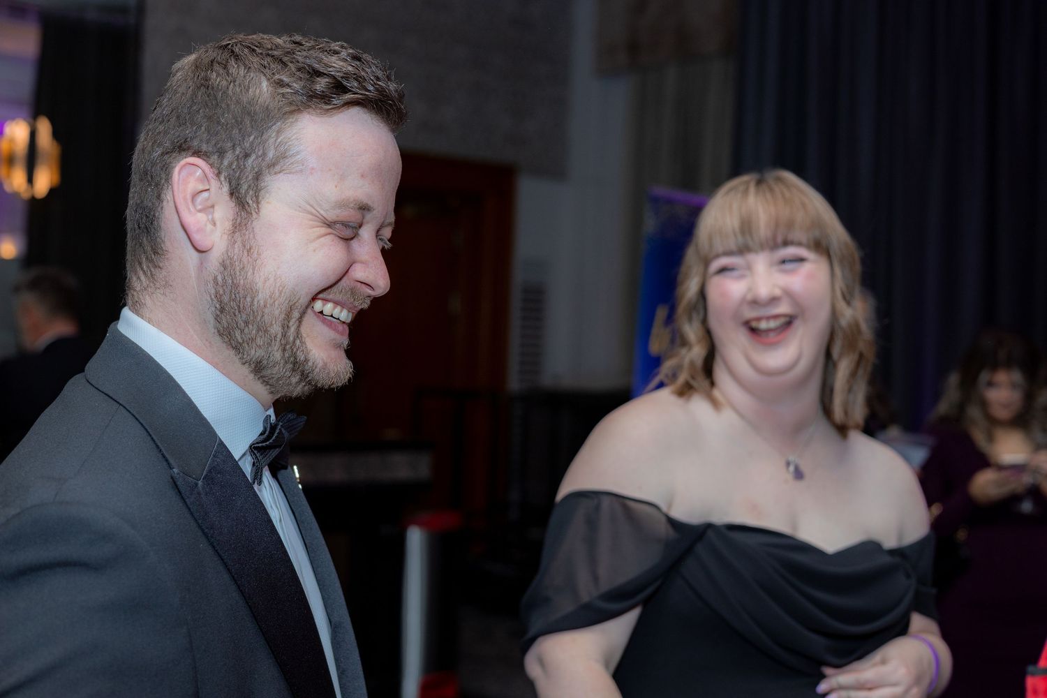 Event guests sharing laughter and conversation at a formal gathering.