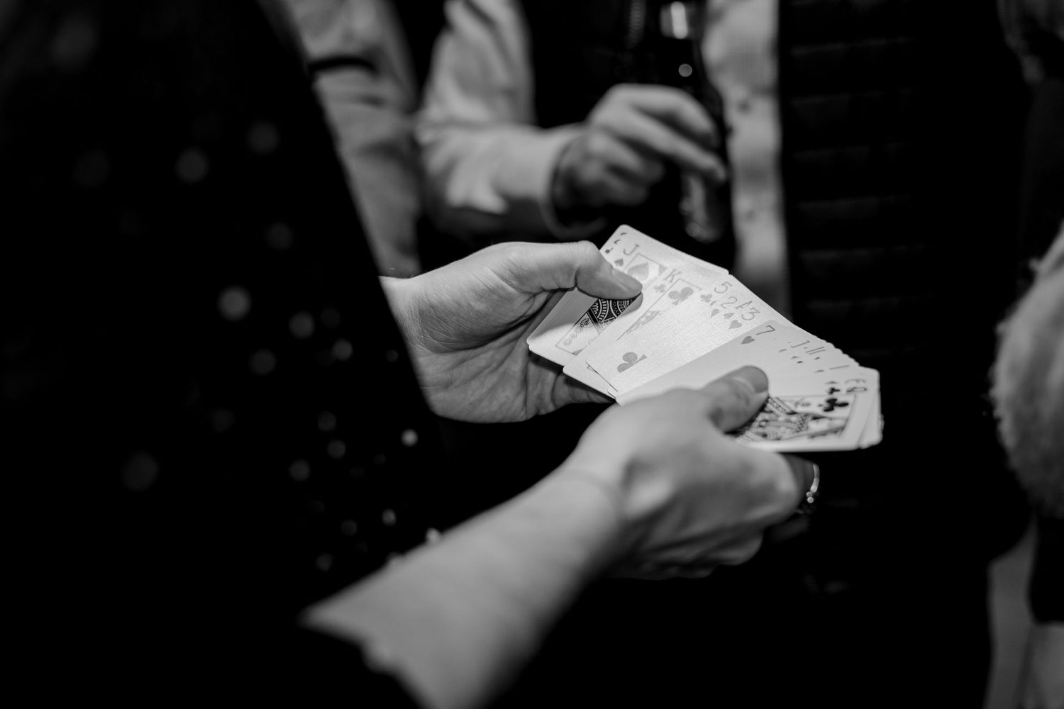 Black and white close-up of hands exchanging or showing something.