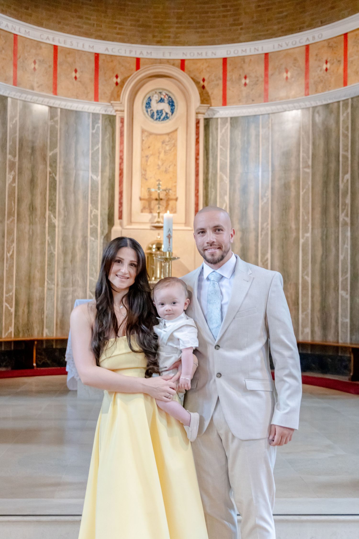 Family group poses together in an elegant church interior with yellow and white attire.