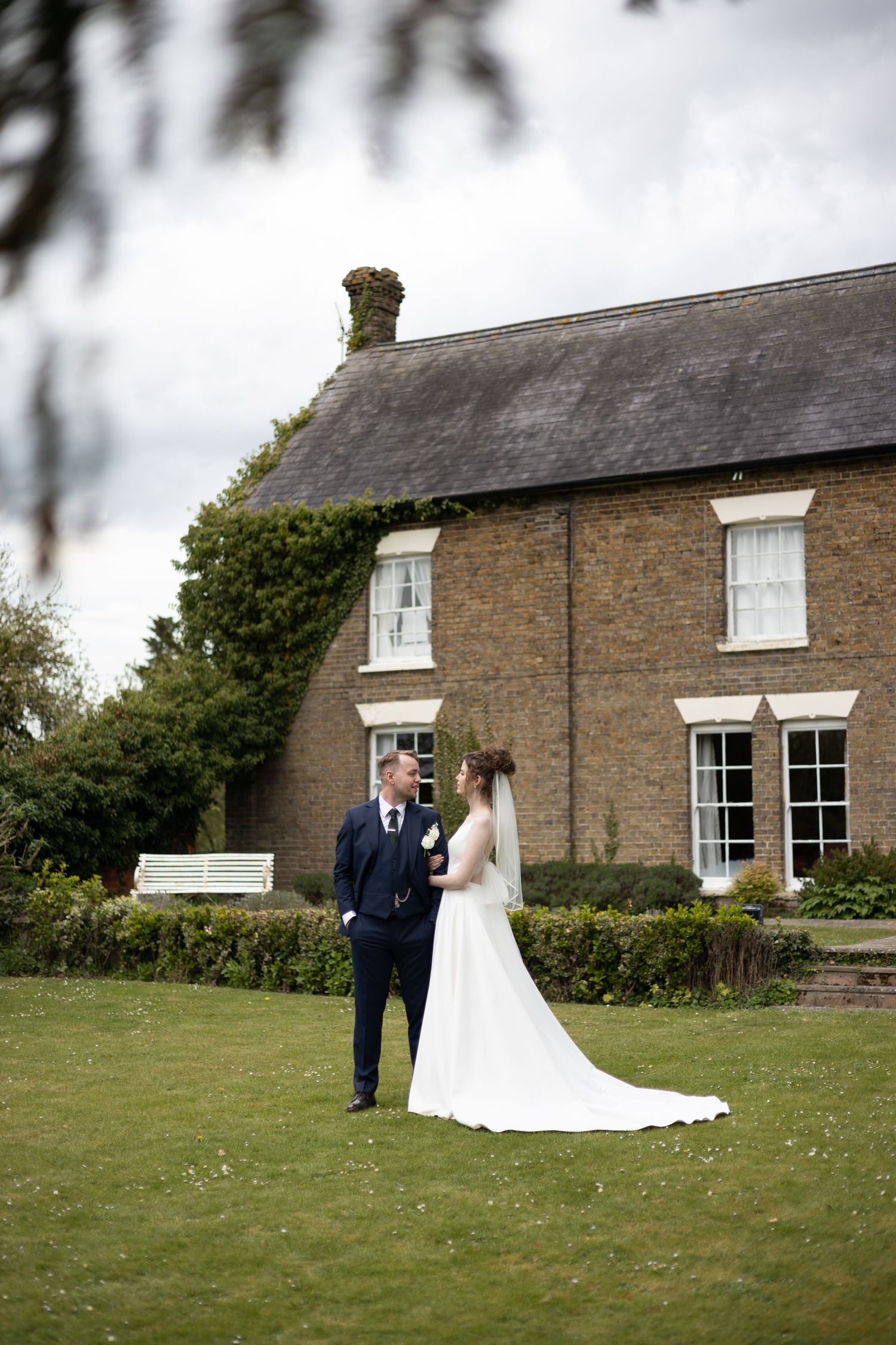 Elegant wedding photography session on the lawn of a historic stone farmhouse.