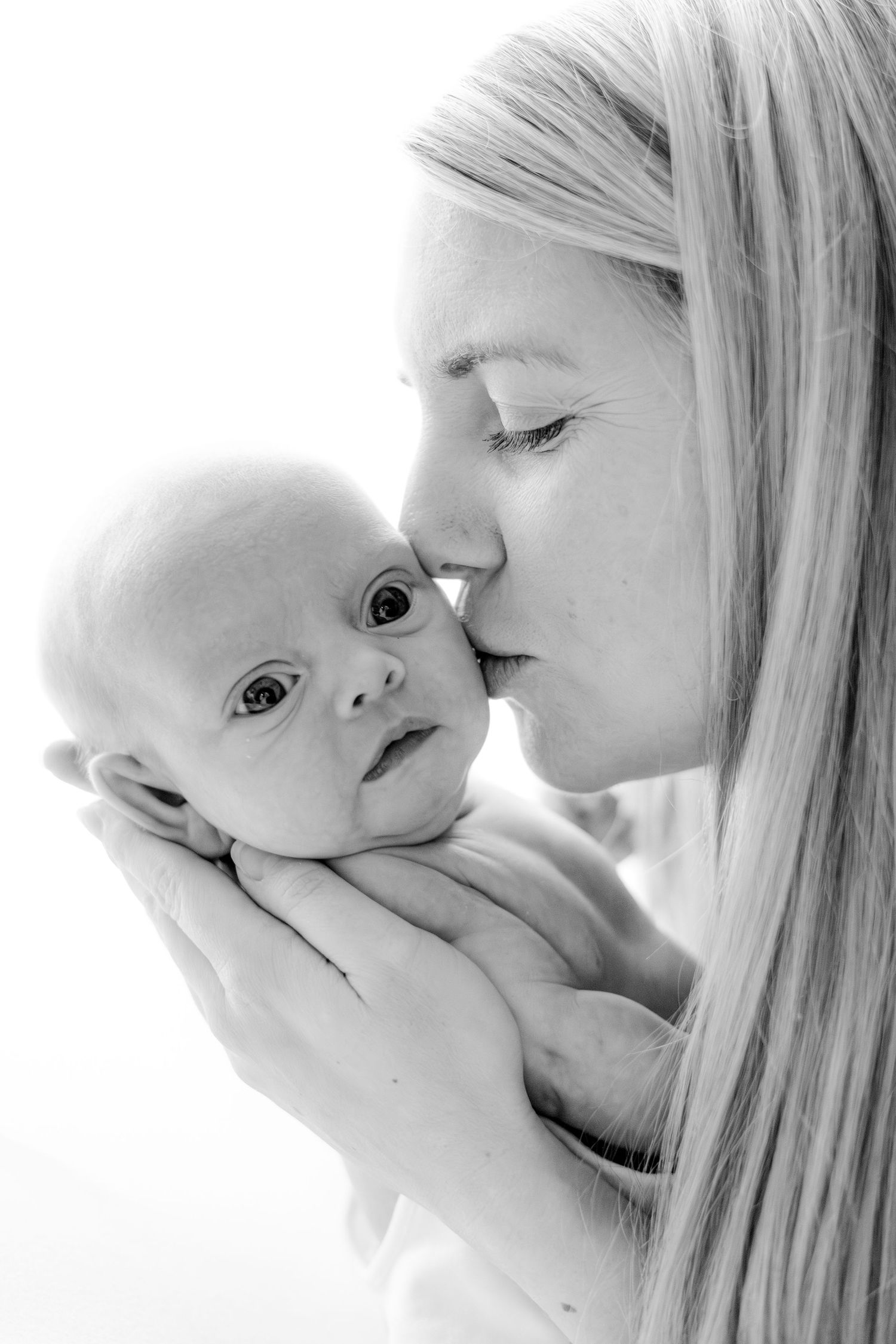 Black and white portrait of tender moment between parent and infant.