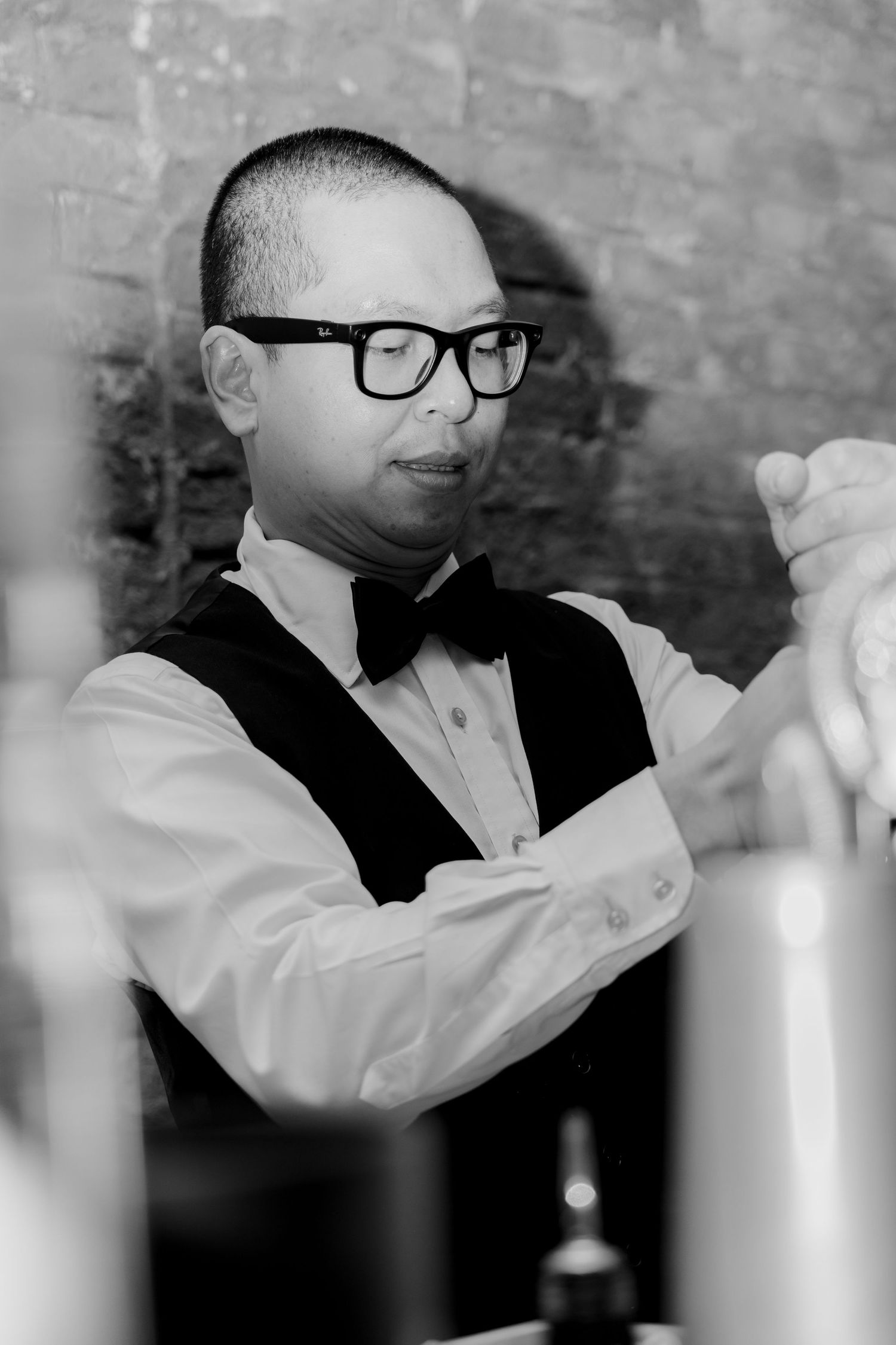Black and white image of formal dining setup with candlelight and elegant place settings.