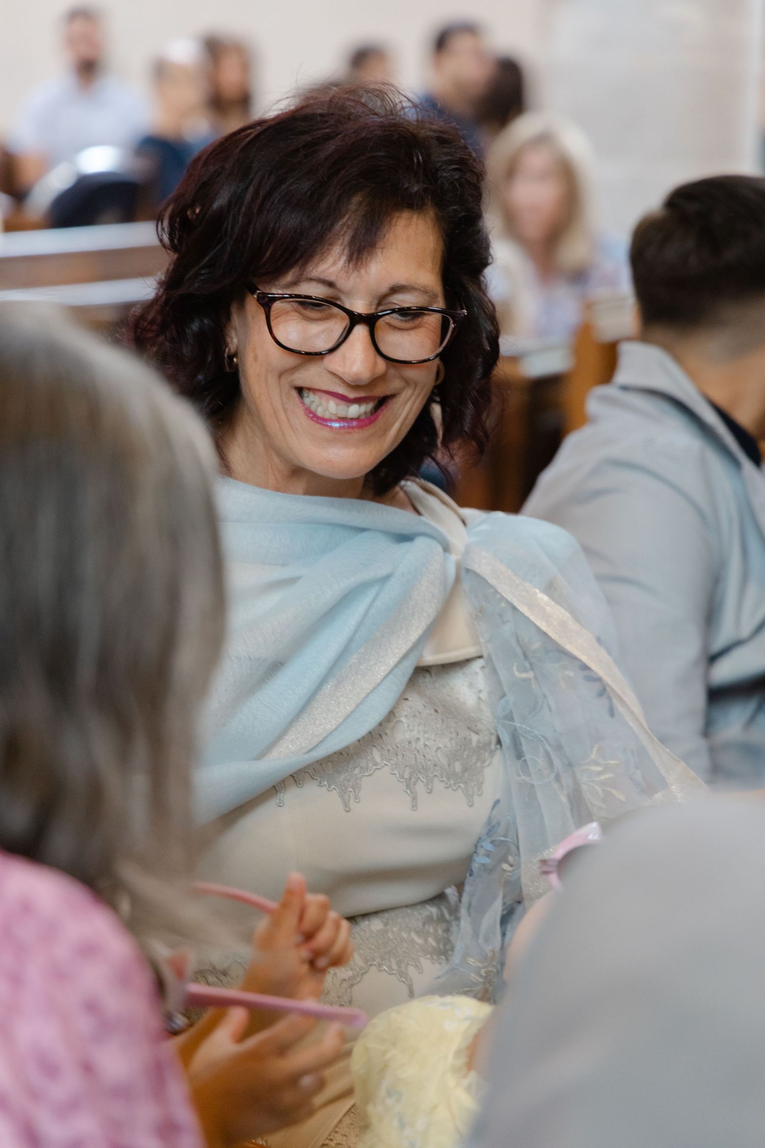 A guest enjoying a celebration in formal attire at an indoor gathering.