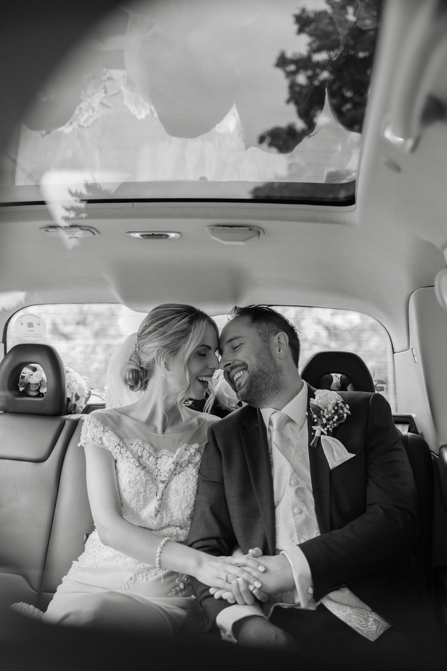 Romantic black and white wedding portraits captured in the back of a luxury car.