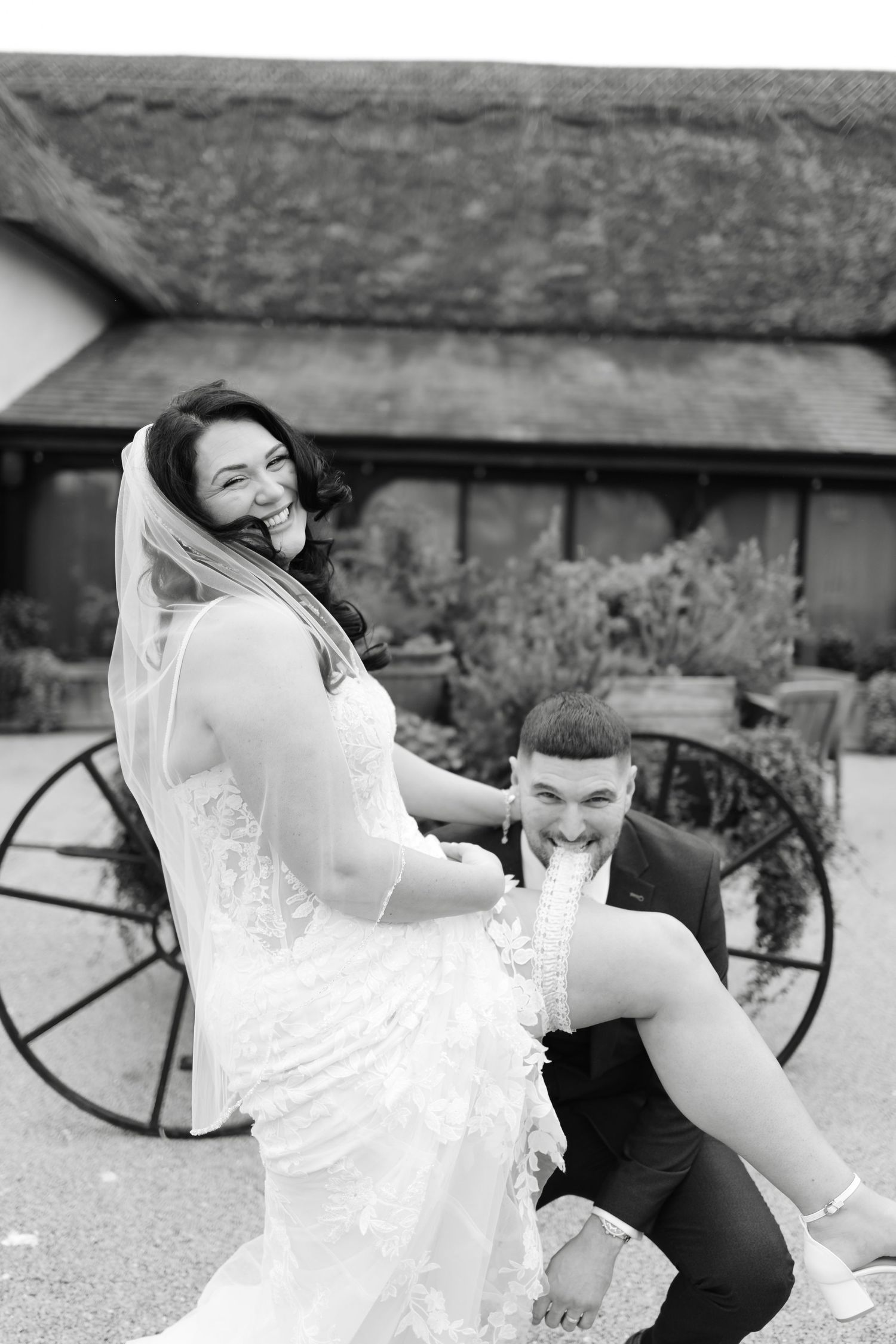 Artistic black and white wedding photos showing couple in dynamic poses outdoors.
