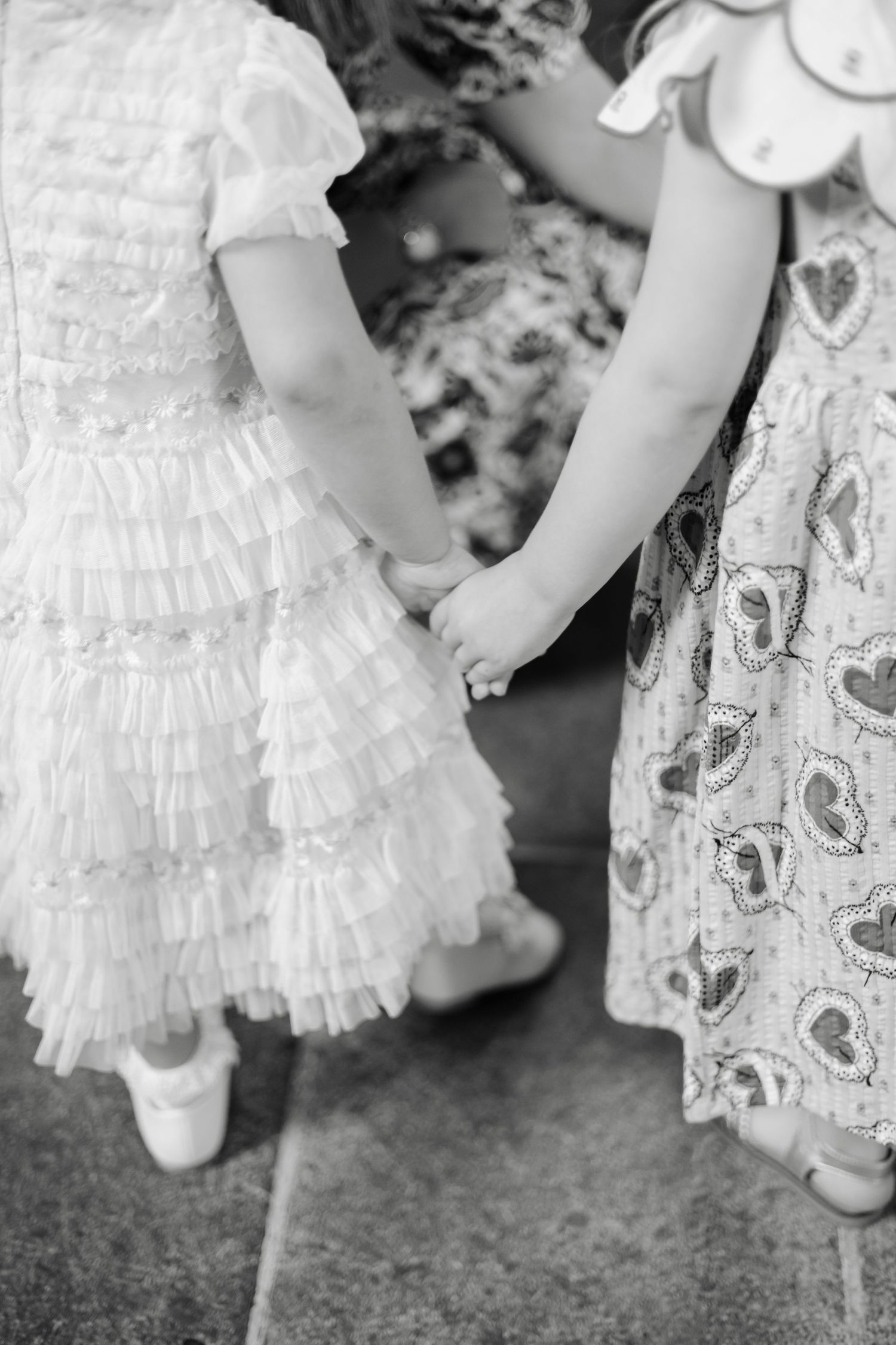 Close-up of white lace christening gowns and baby shoes.