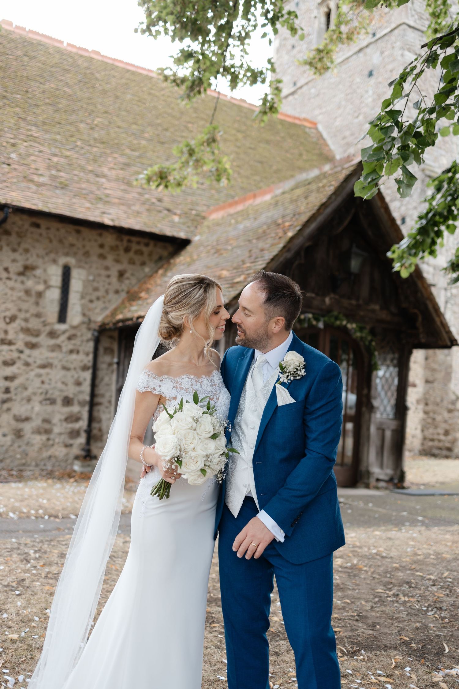 Romantic wedding portraits captured outside historic stone church entrance.