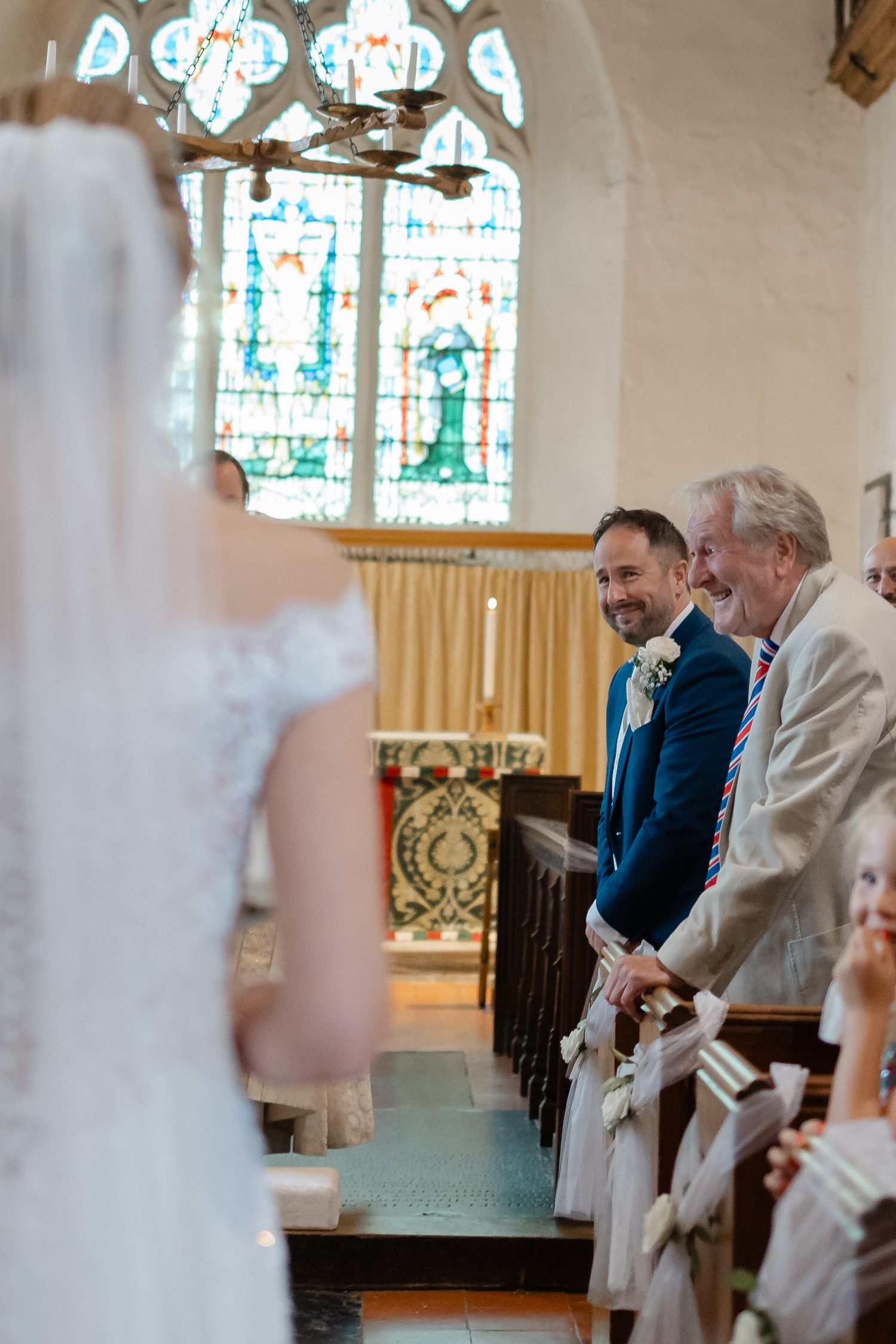 Church ceremony with stained glass windows and traditional altar setting.