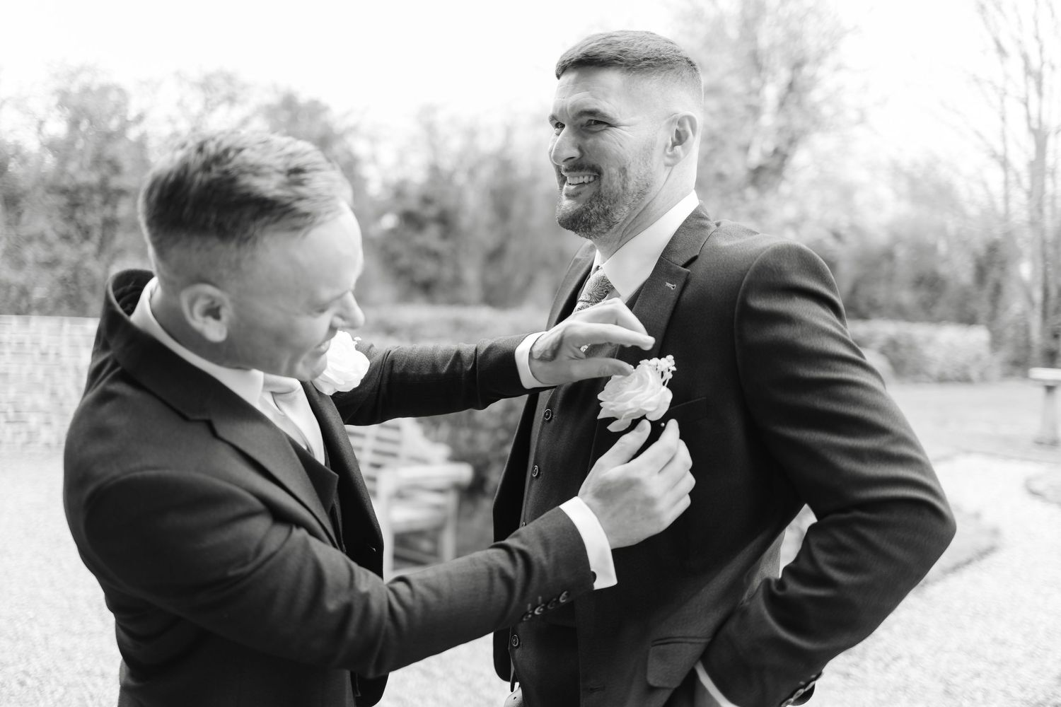 Playful black and white photos of groomsmen having fun outdoors.