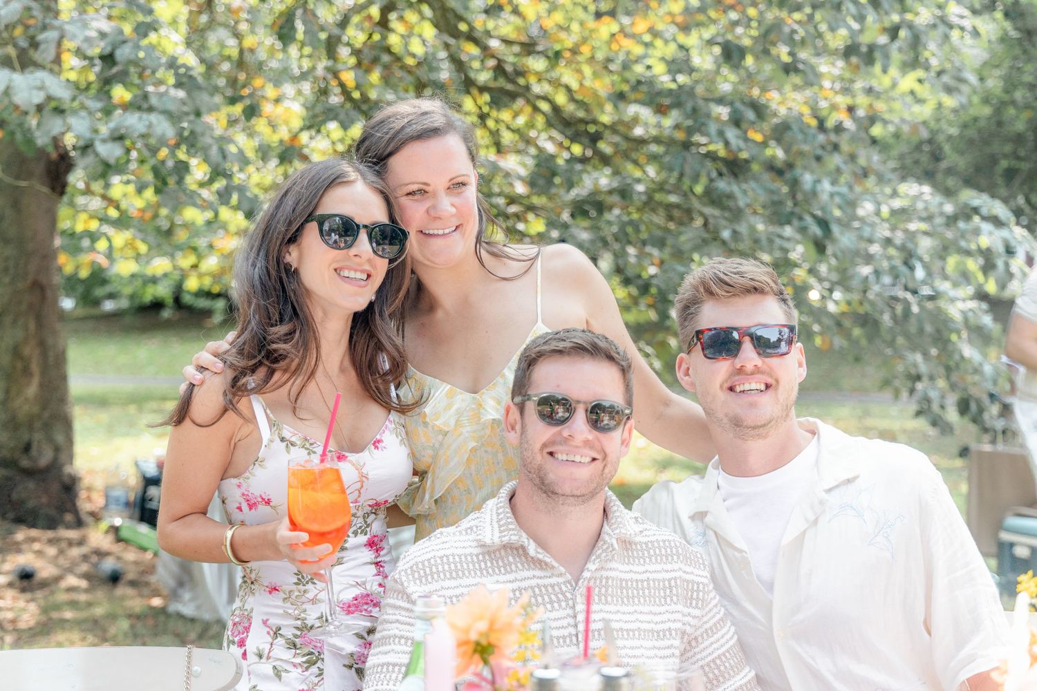 Group enjoying cocktails and sunshine at outdoor summer party.